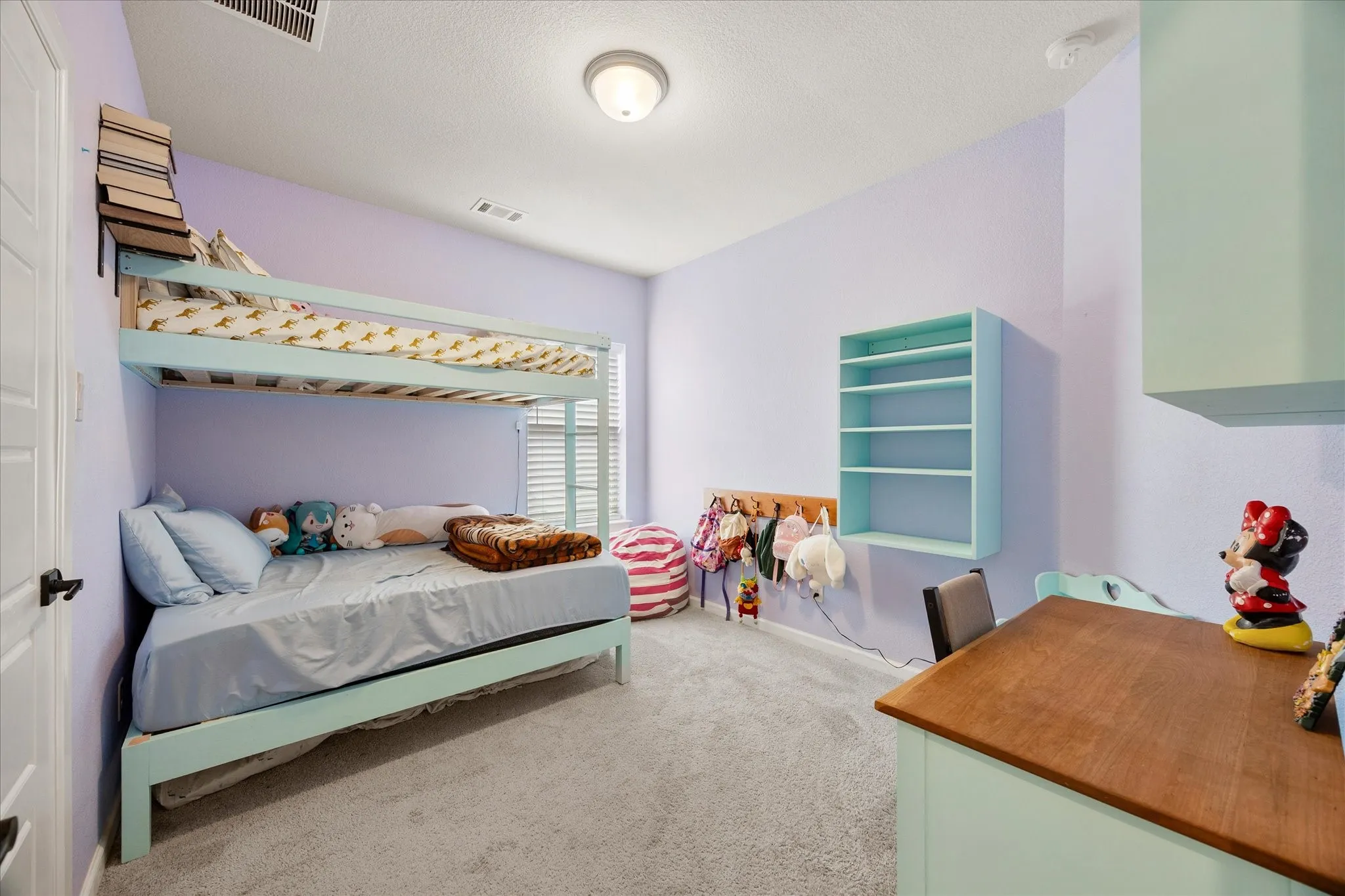 Spacious room featuring vaulted ceilings, light-colored carpeting, and a window with blinds