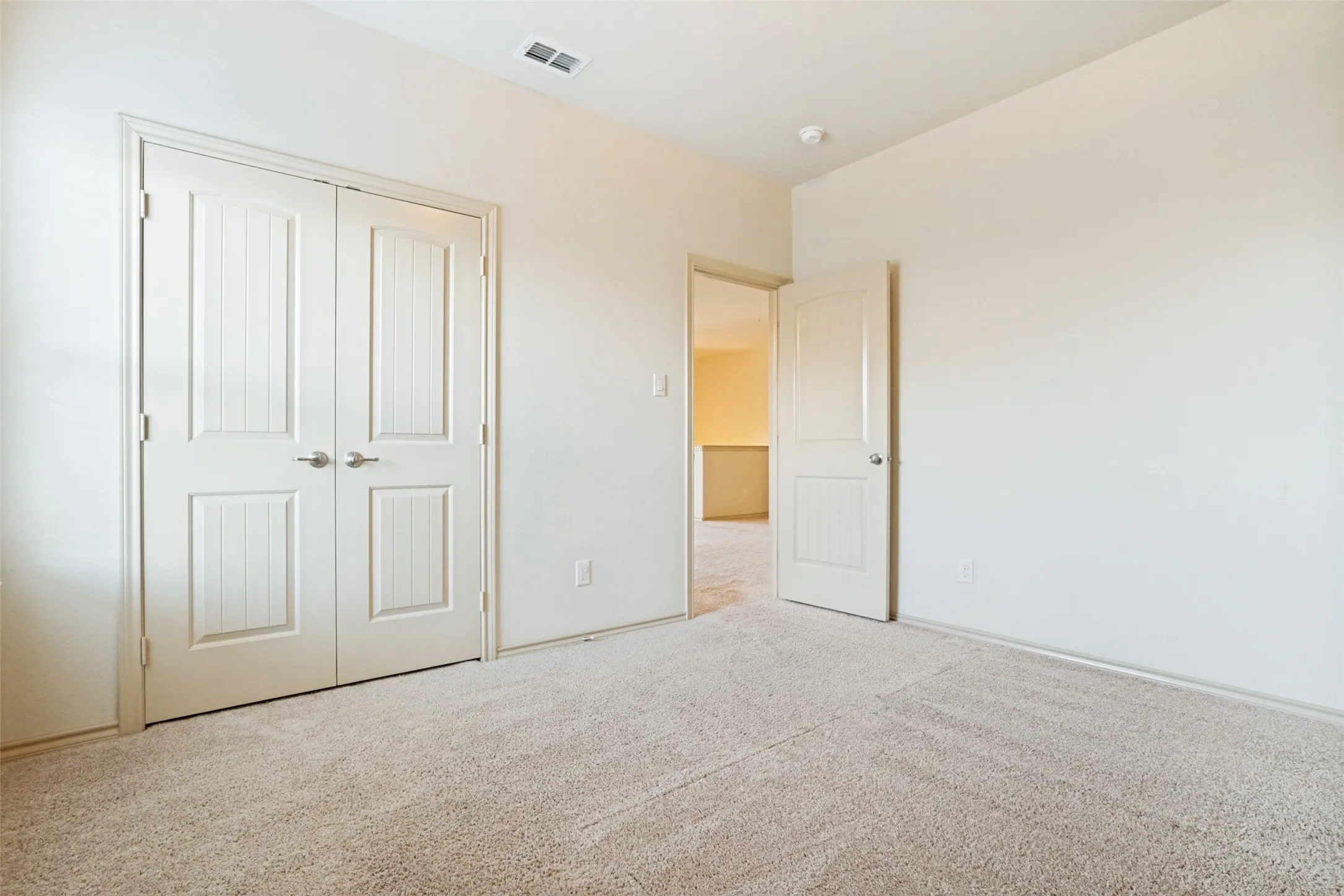 Neutral-toned carpeting extends throughout this room, complemented by white walls and trim