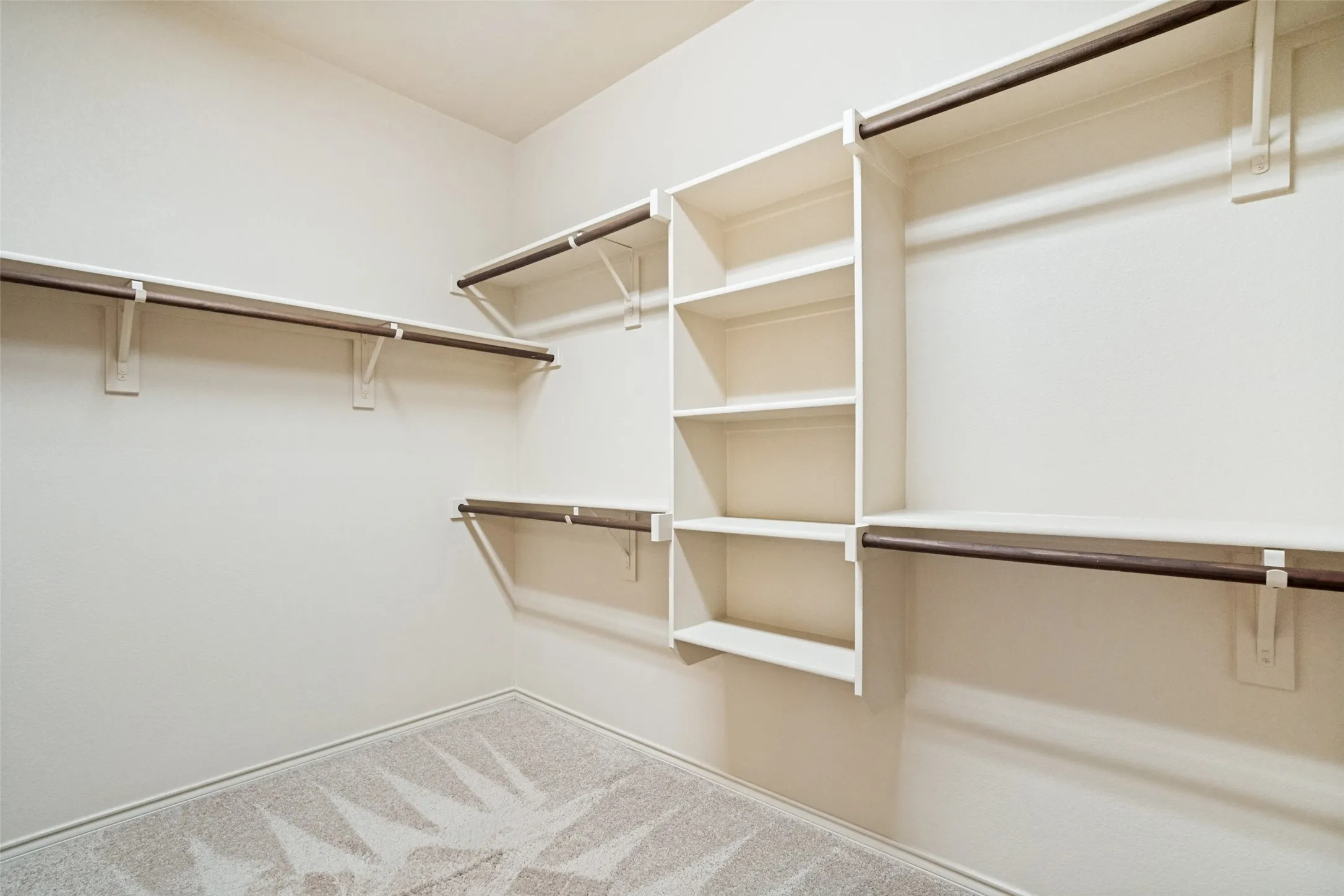 Spacious closet with multiple hanging rods and integrated shelving