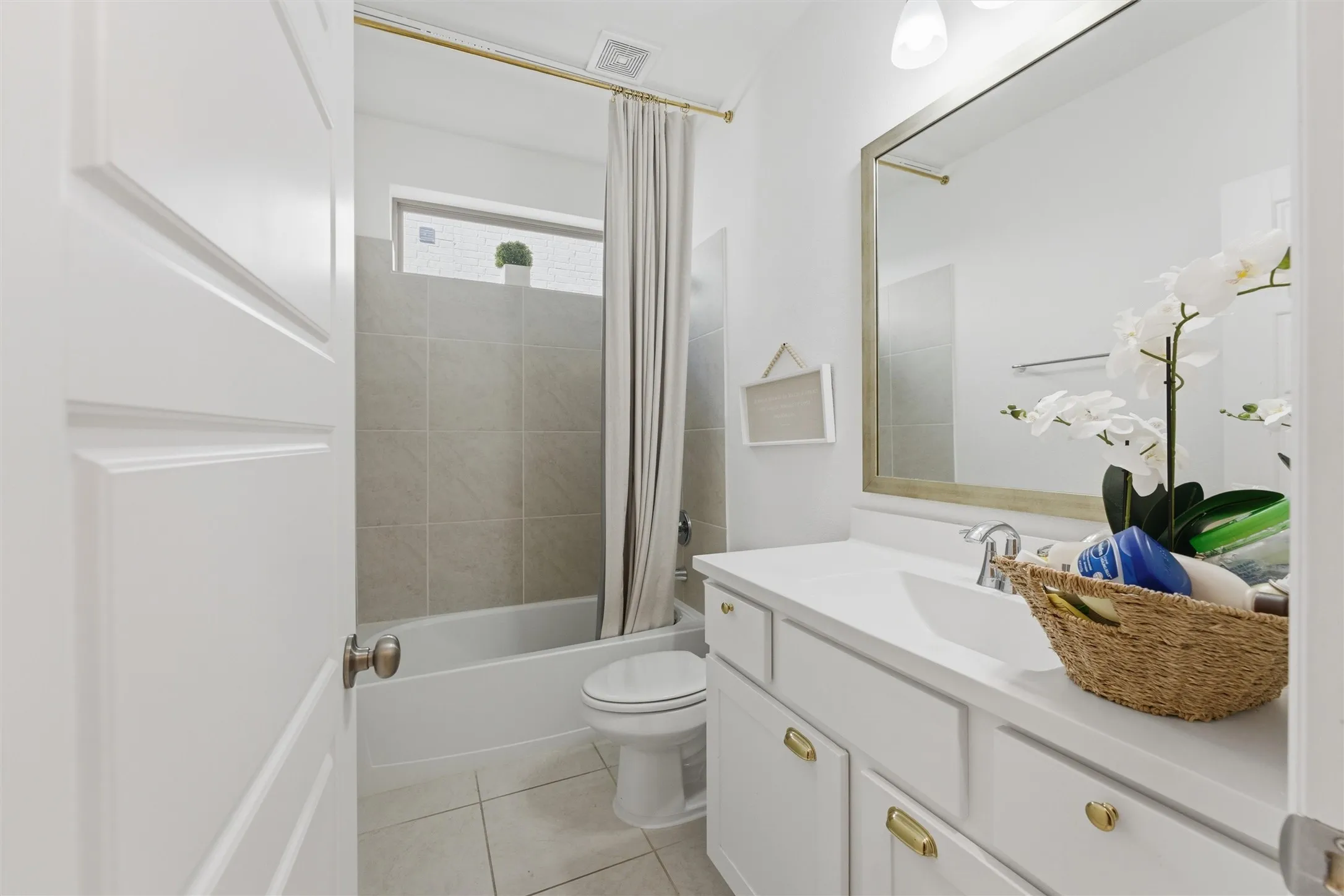 Bathroom featuring a white vanity with gold-tone hardware, rectangular undermount sink, and polished chrome faucet