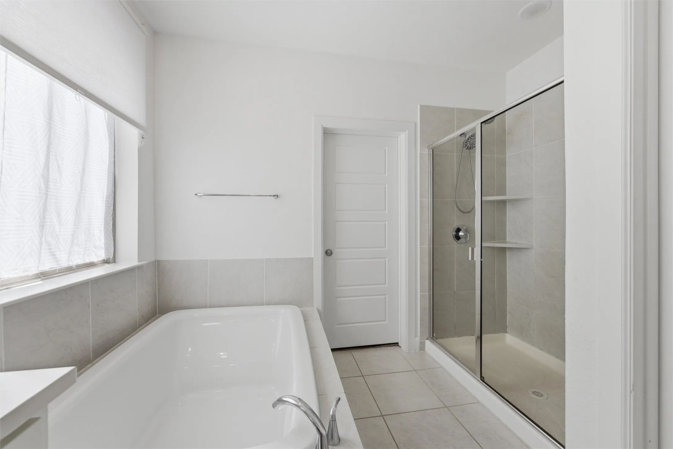 Soaking tub and enclosed shower with tiled walls and flooring