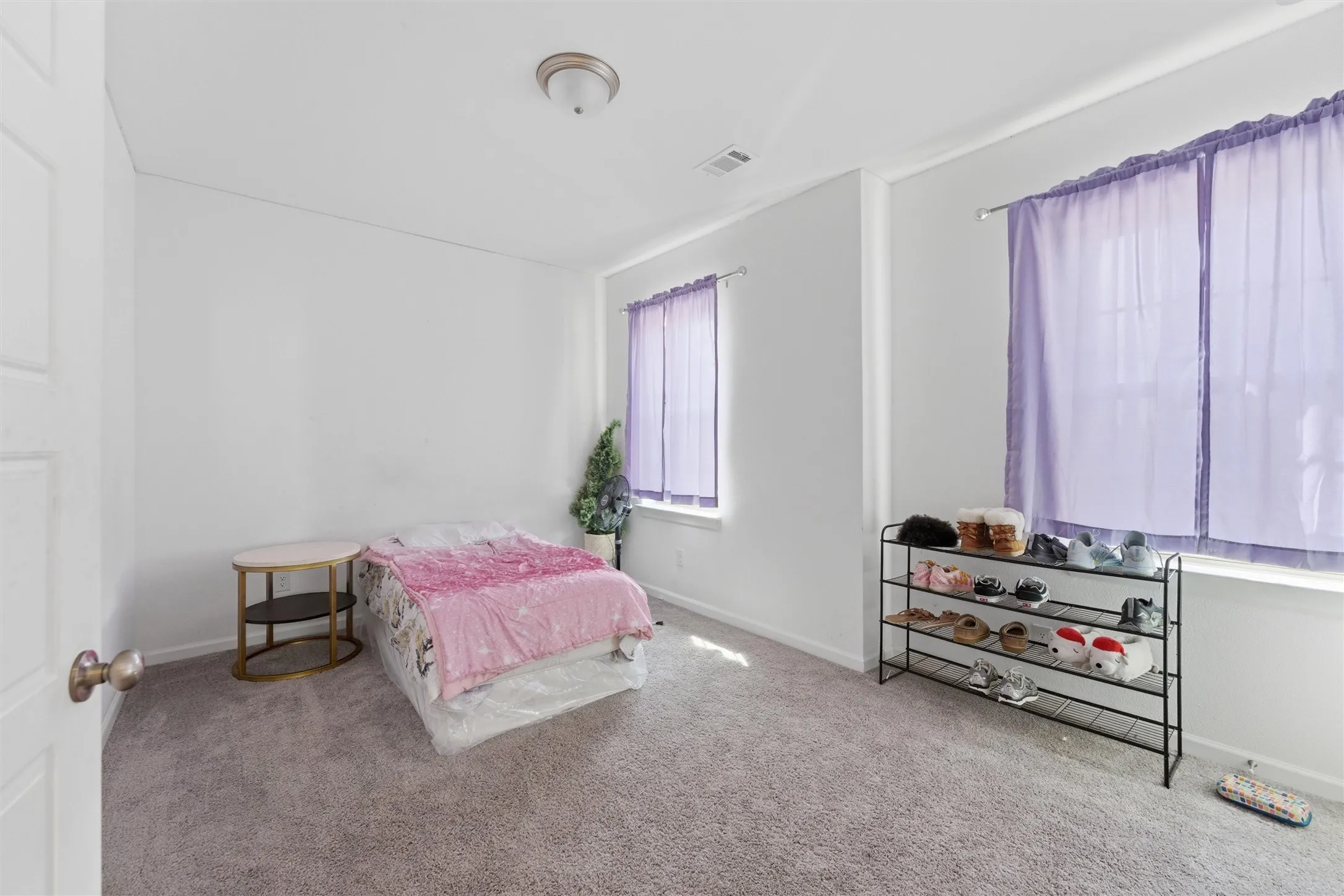 Carpeted room featuring white walls and a ceiling-mounted light fixture