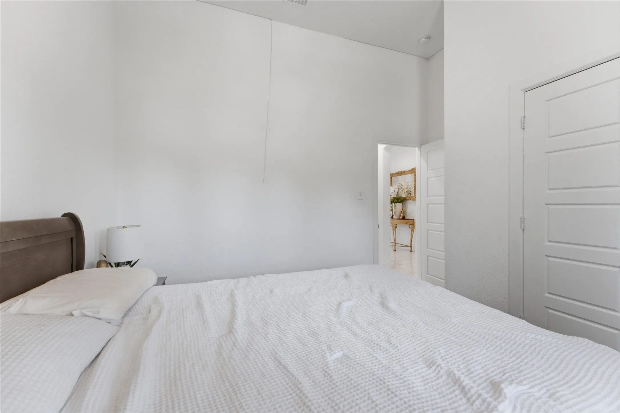 Interior space featuring a white paneled door and high ceilings