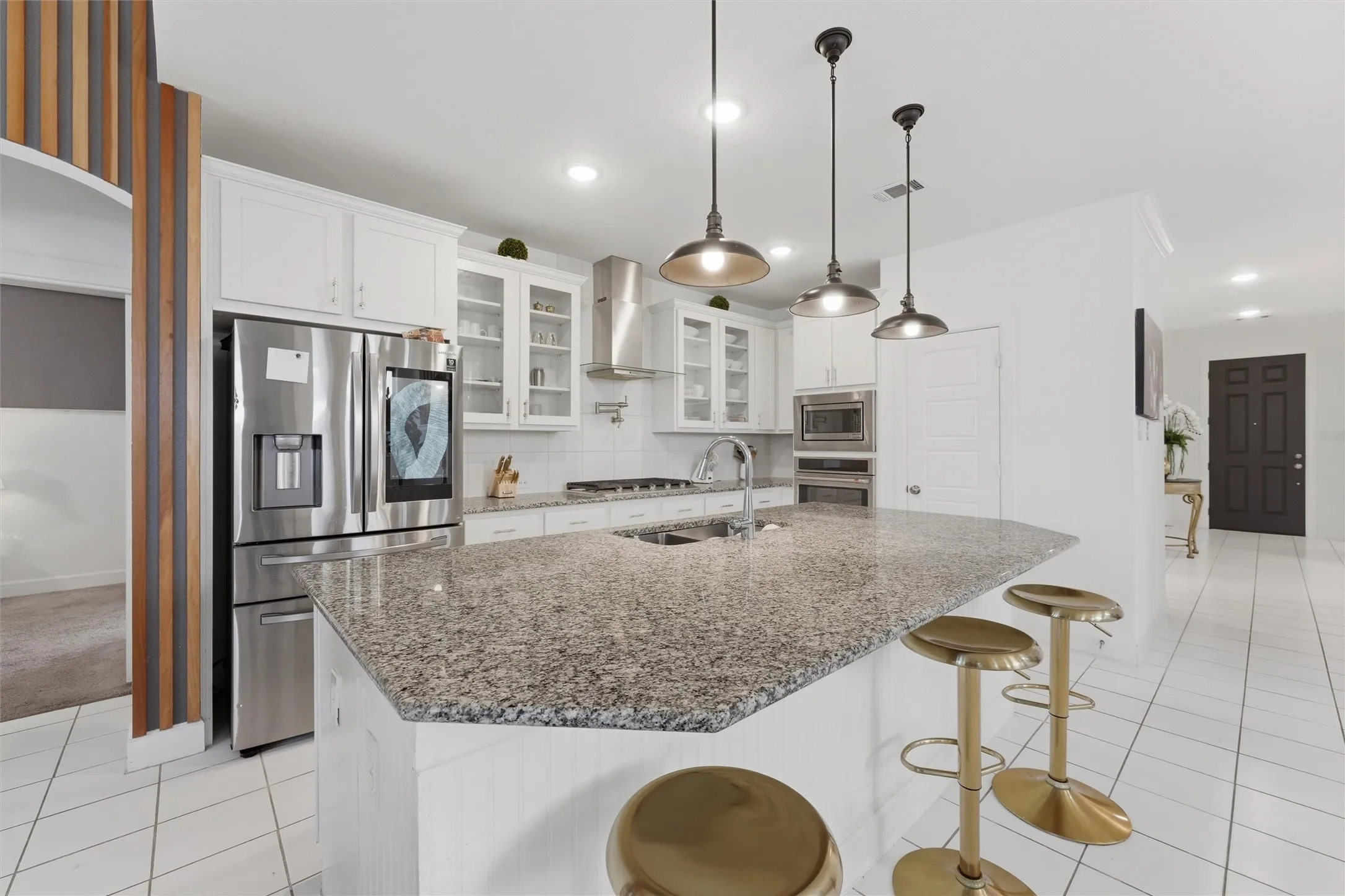Expansive kitchen island featuring a speckled countertop and integrated sink