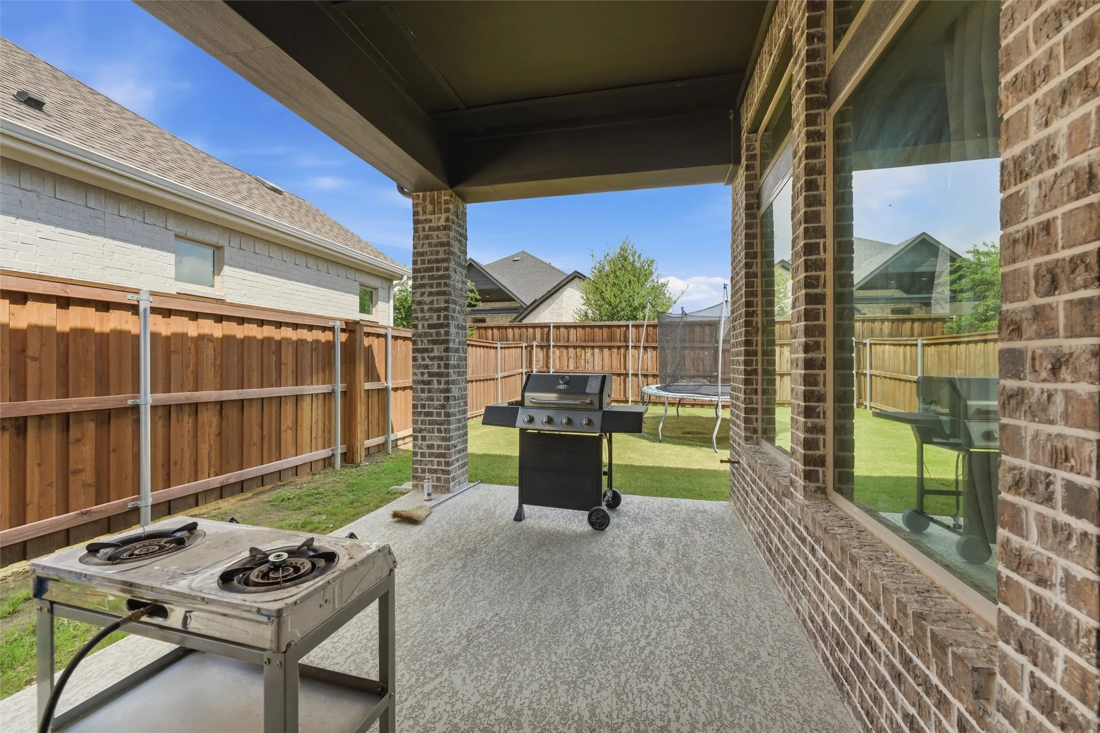 Covered patio featuring an outdoor ceiling, brick columns, and a textured concrete surface