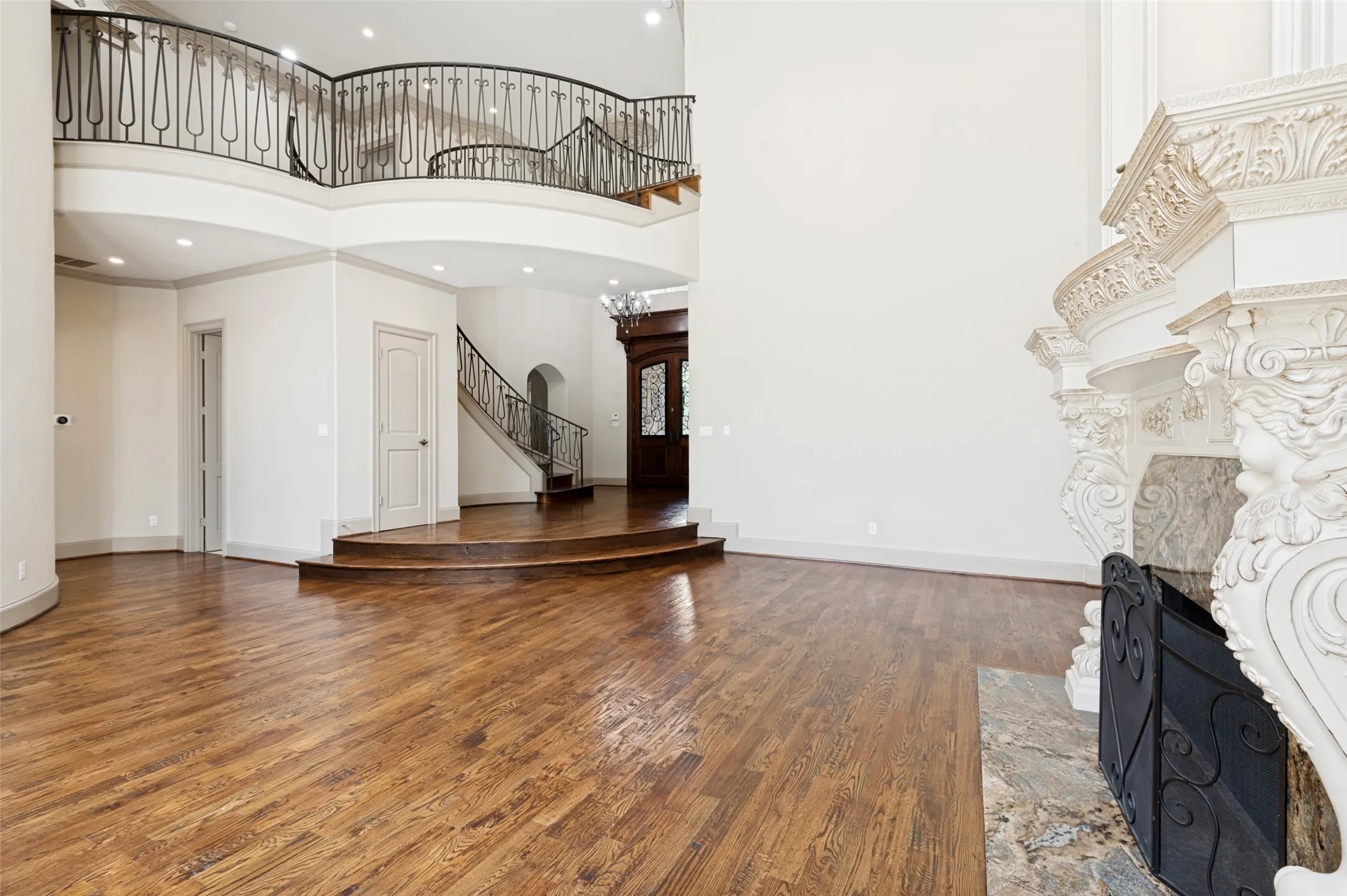 View of elegant entry from formal living. Beautifully carved molding accenting fireplace.