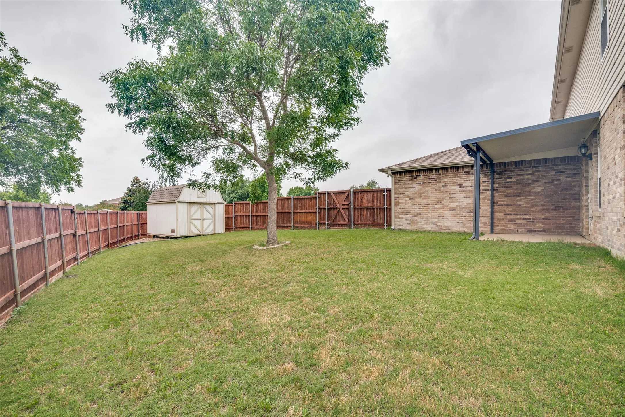 Large backyard with covered patio and 10X12 storage shed