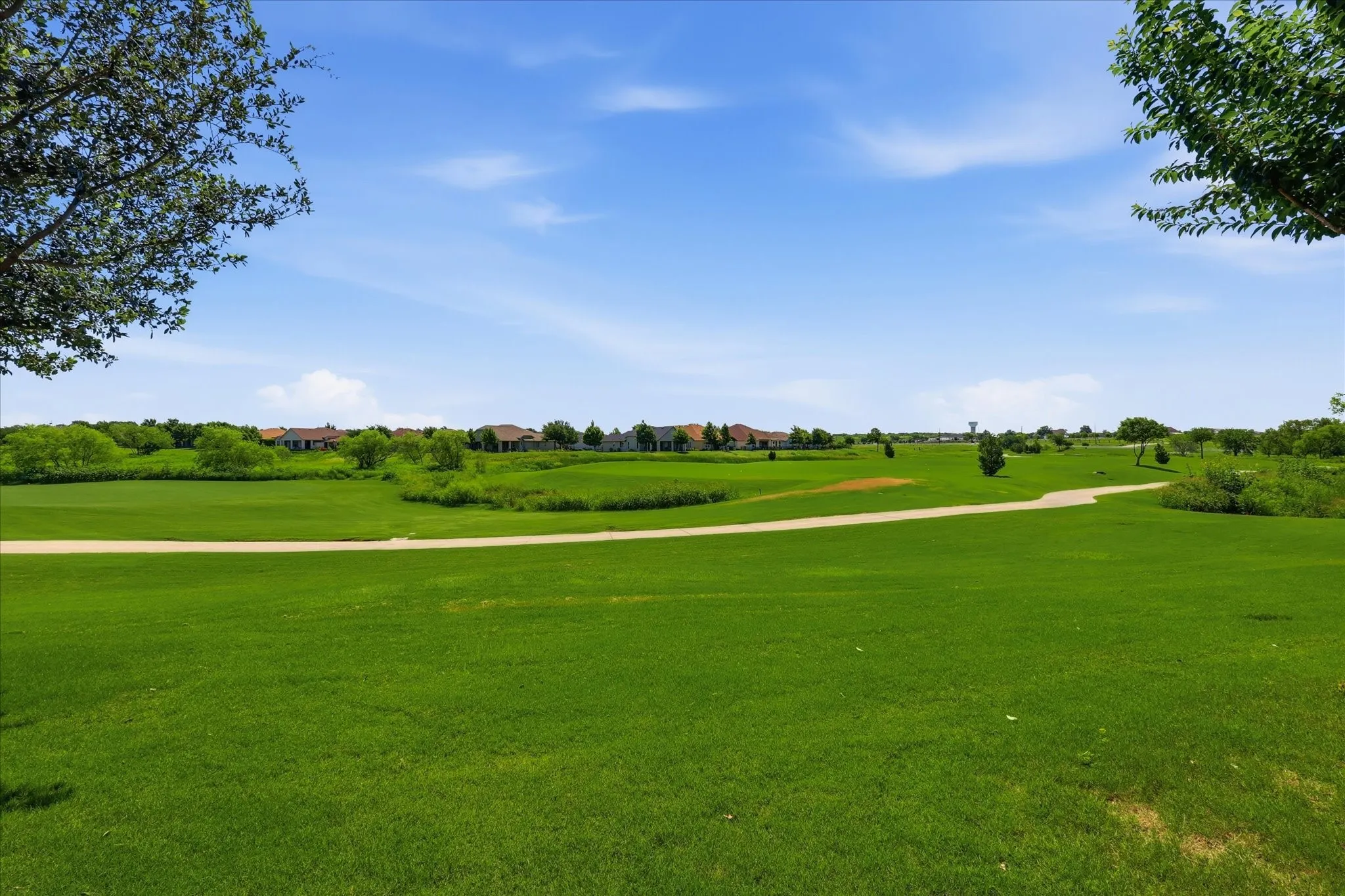 Expansive green landscape featuring a paved pathway