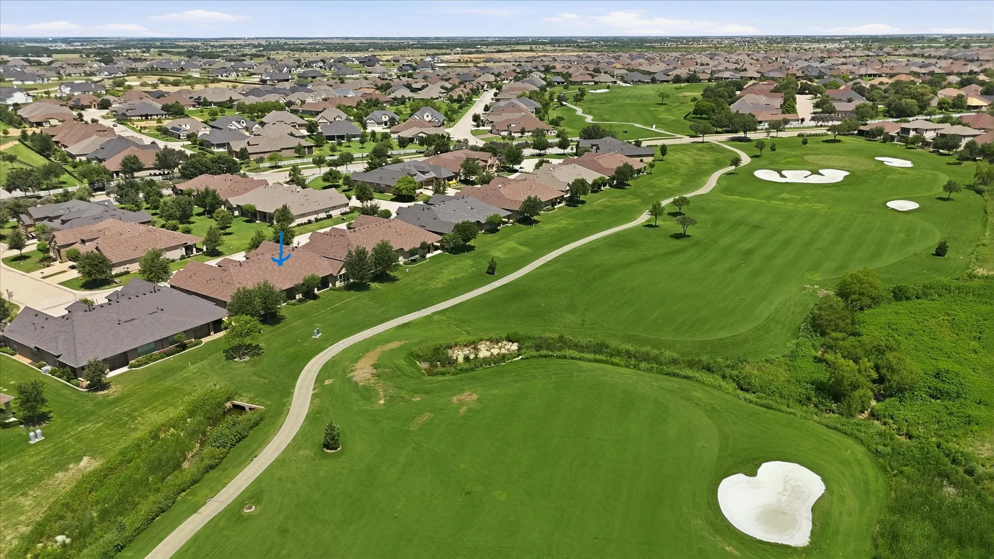 Expansive green space featuring a golf course with sand traps and cart paths