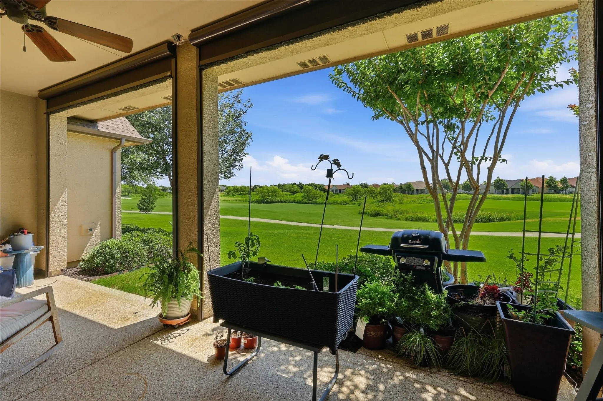 Covered patio with a ceiling fan and textured concrete flooring