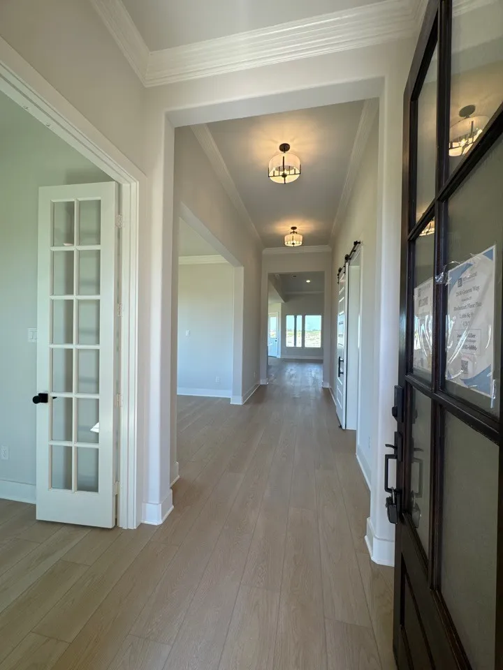 Entry foyer with wood-finish flooring, crown molding, and recessed lighting
