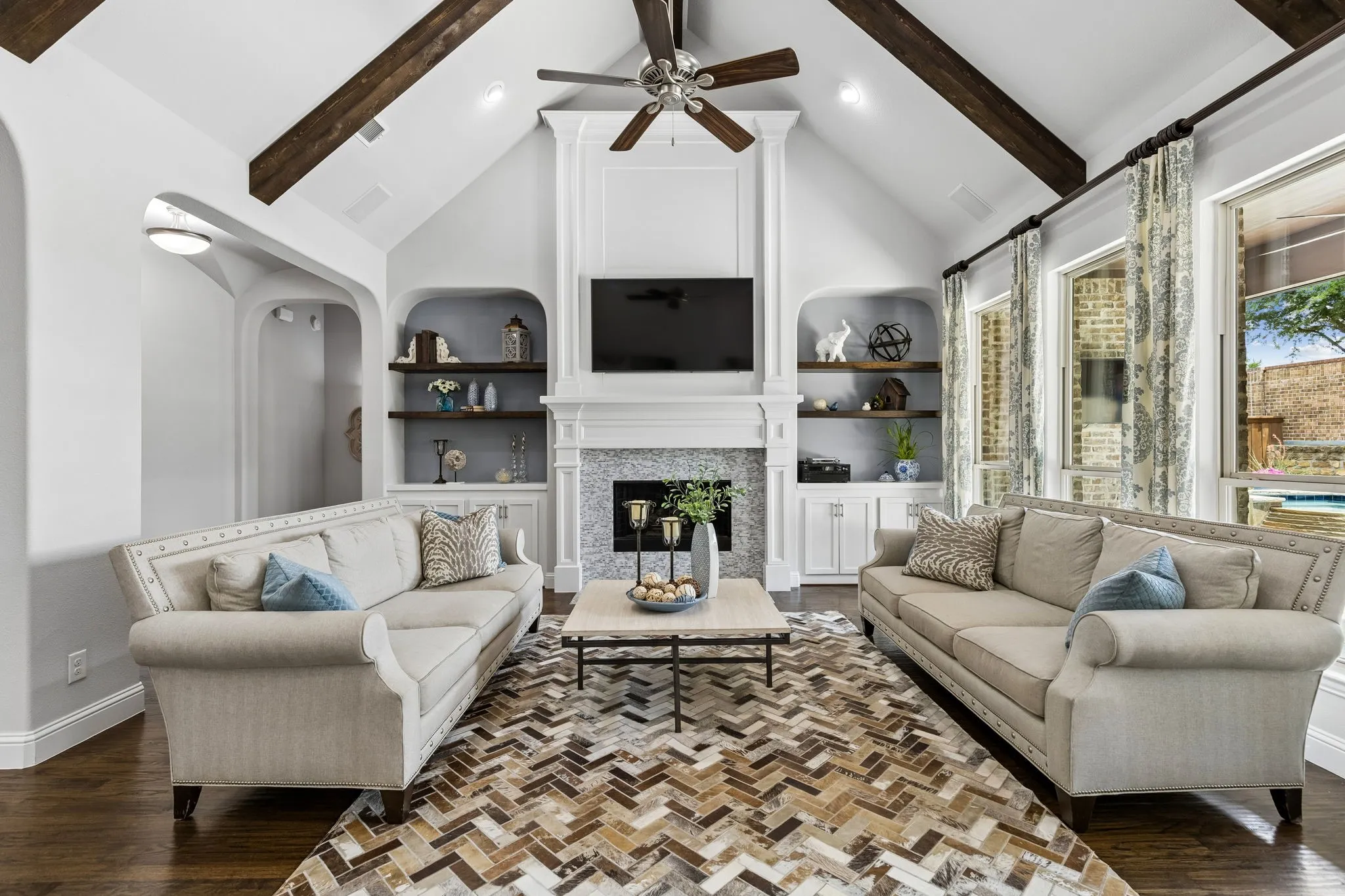 Fireplace anchors the kitchen family room. Built-in cabineets and floating shelves add charm to the room.