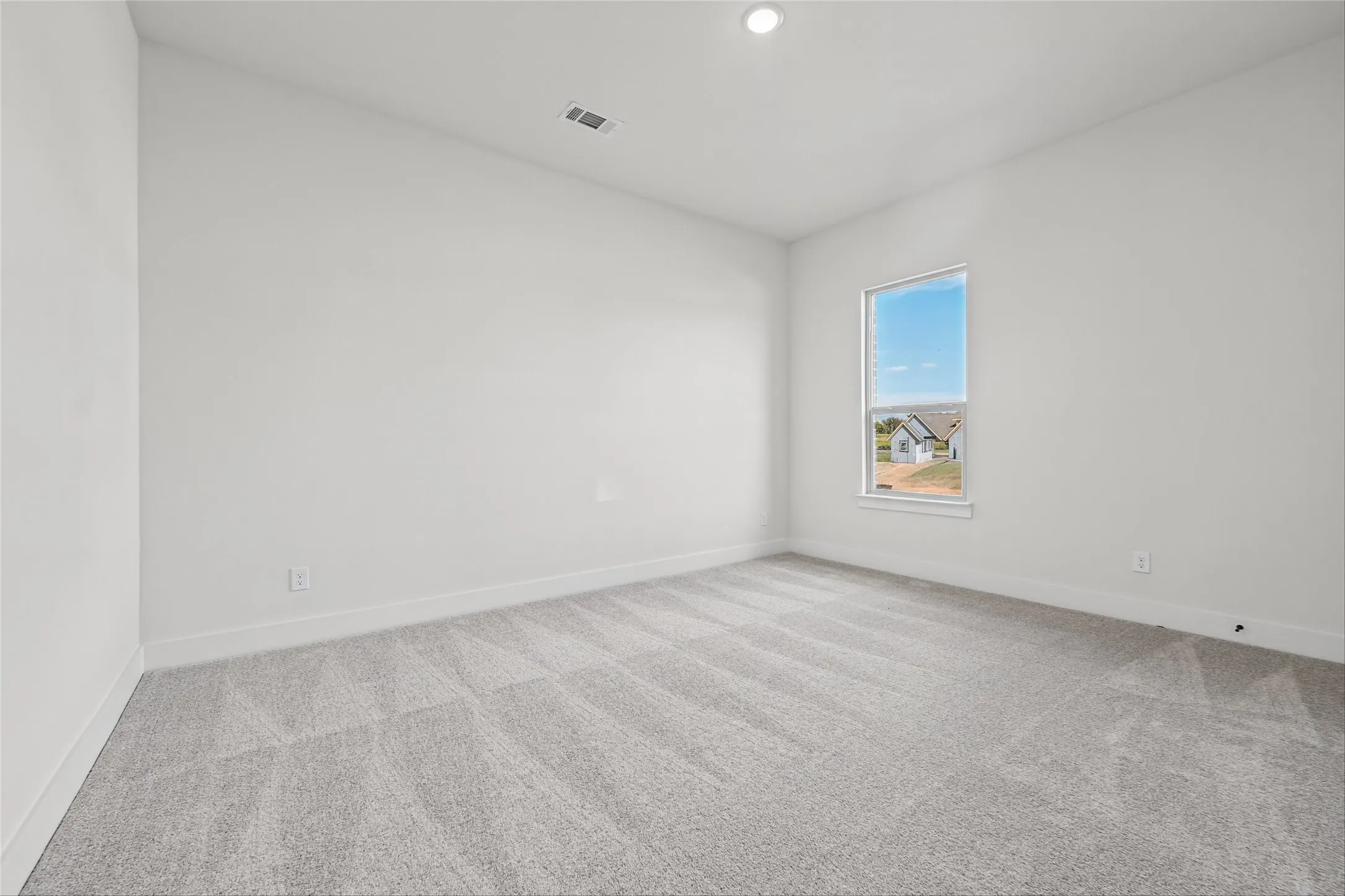 Wall-to-wall carpeting, single window, recessed lighting, and crisp white walls
