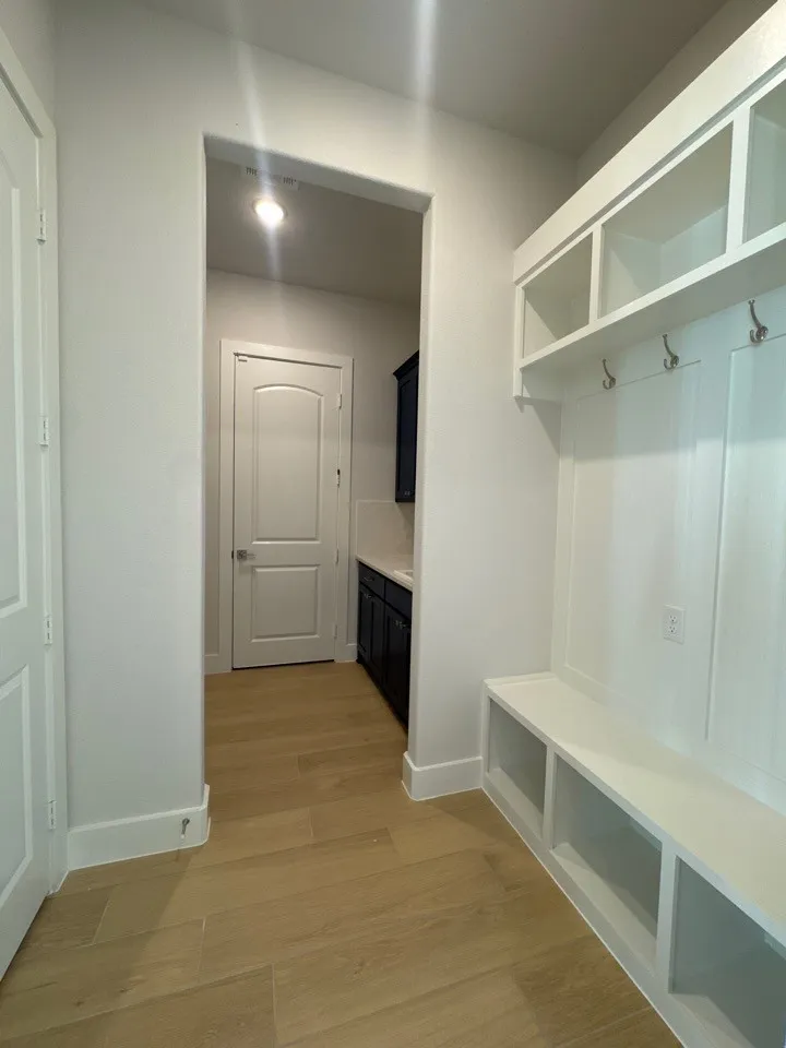 Built-in mudroom bench with cubbies, upper shelving, and coat hooks