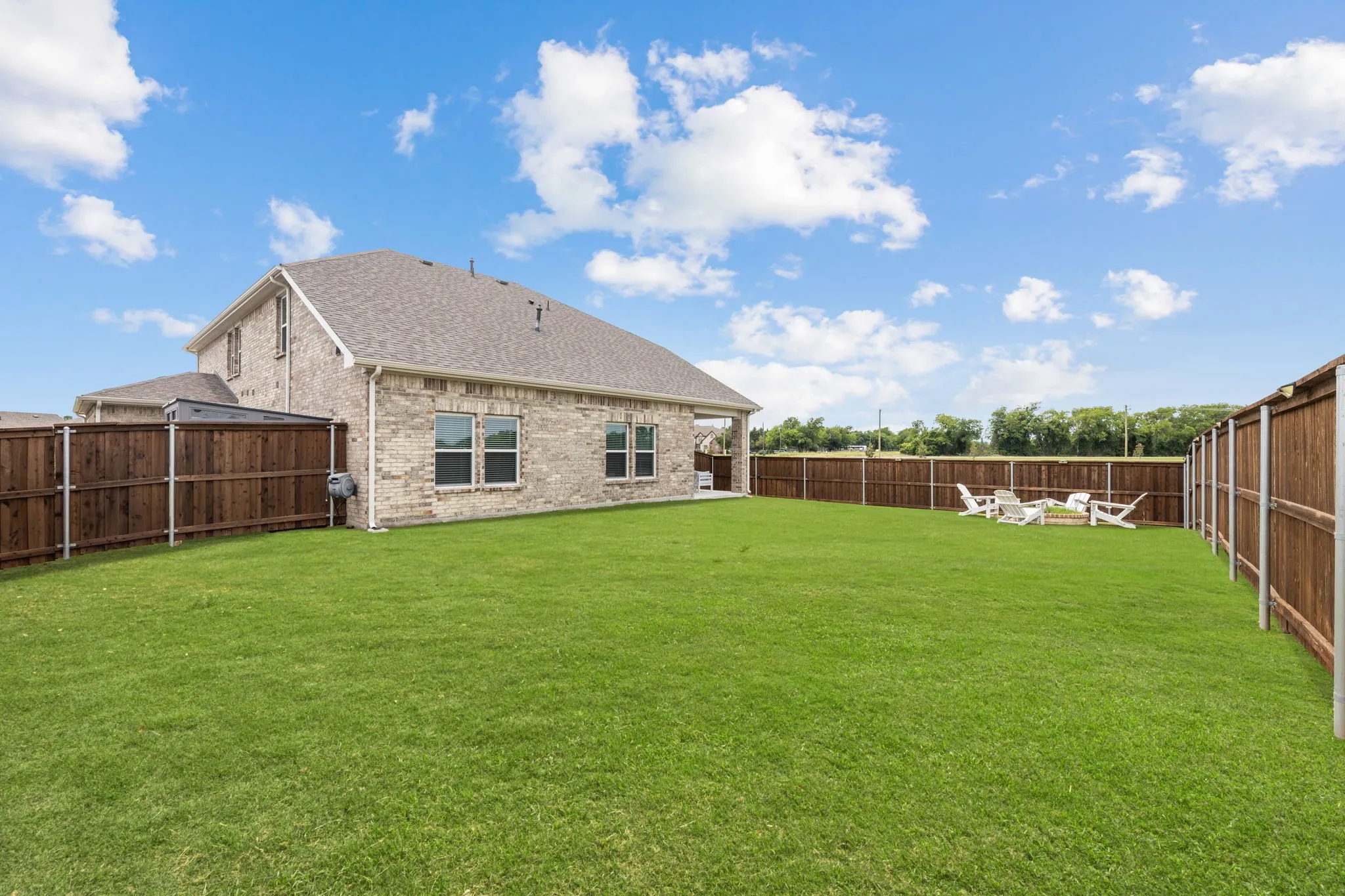 Expansive green lawn with a full privacy fence