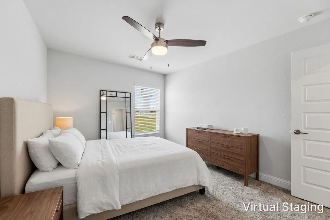 Carpeted bedroom featuring a ceiling fan with light, a white paneled door, and a window with blinds