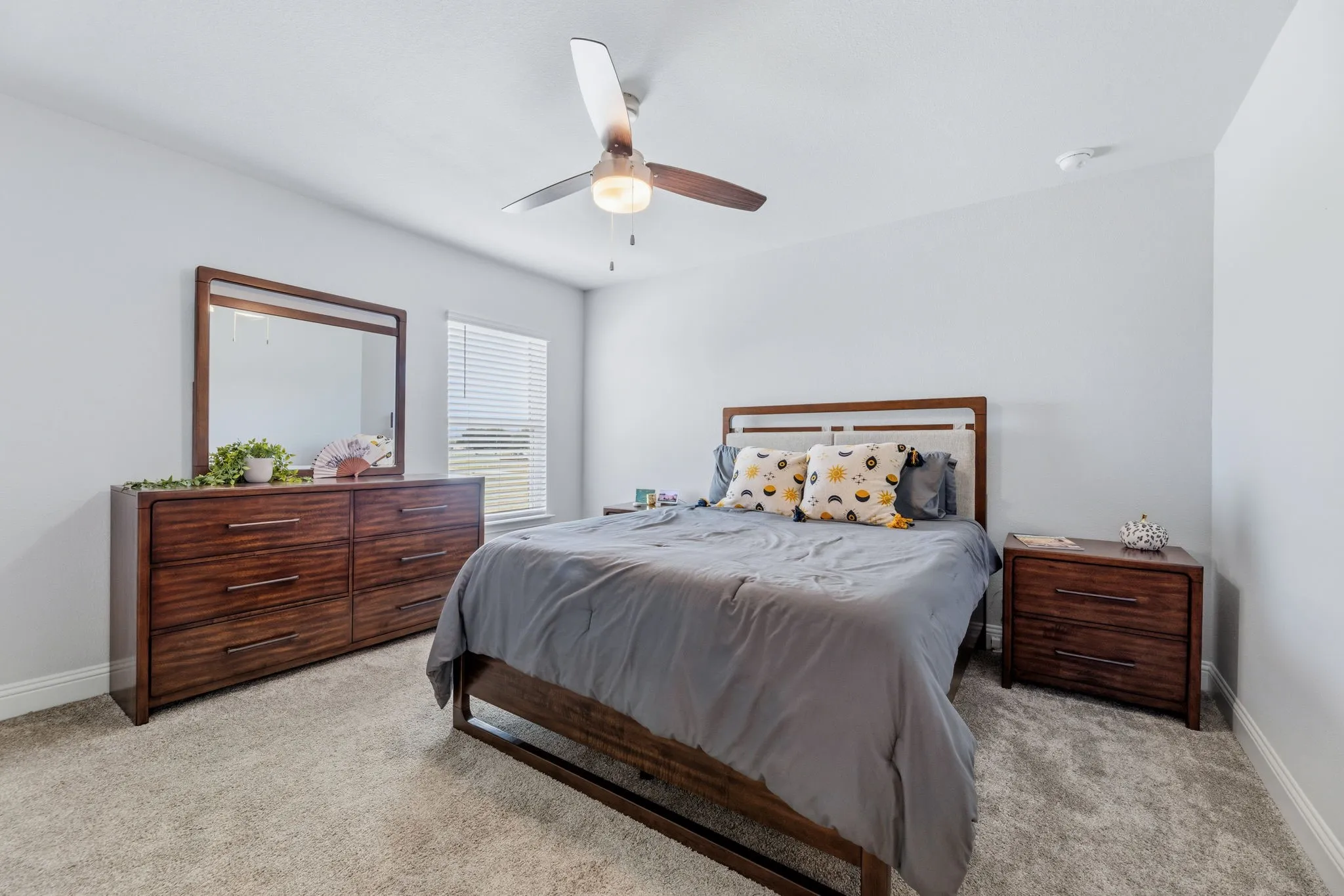 Carpeted room with a ceiling fan light fixture, white walls, and a window with horizontal blinds