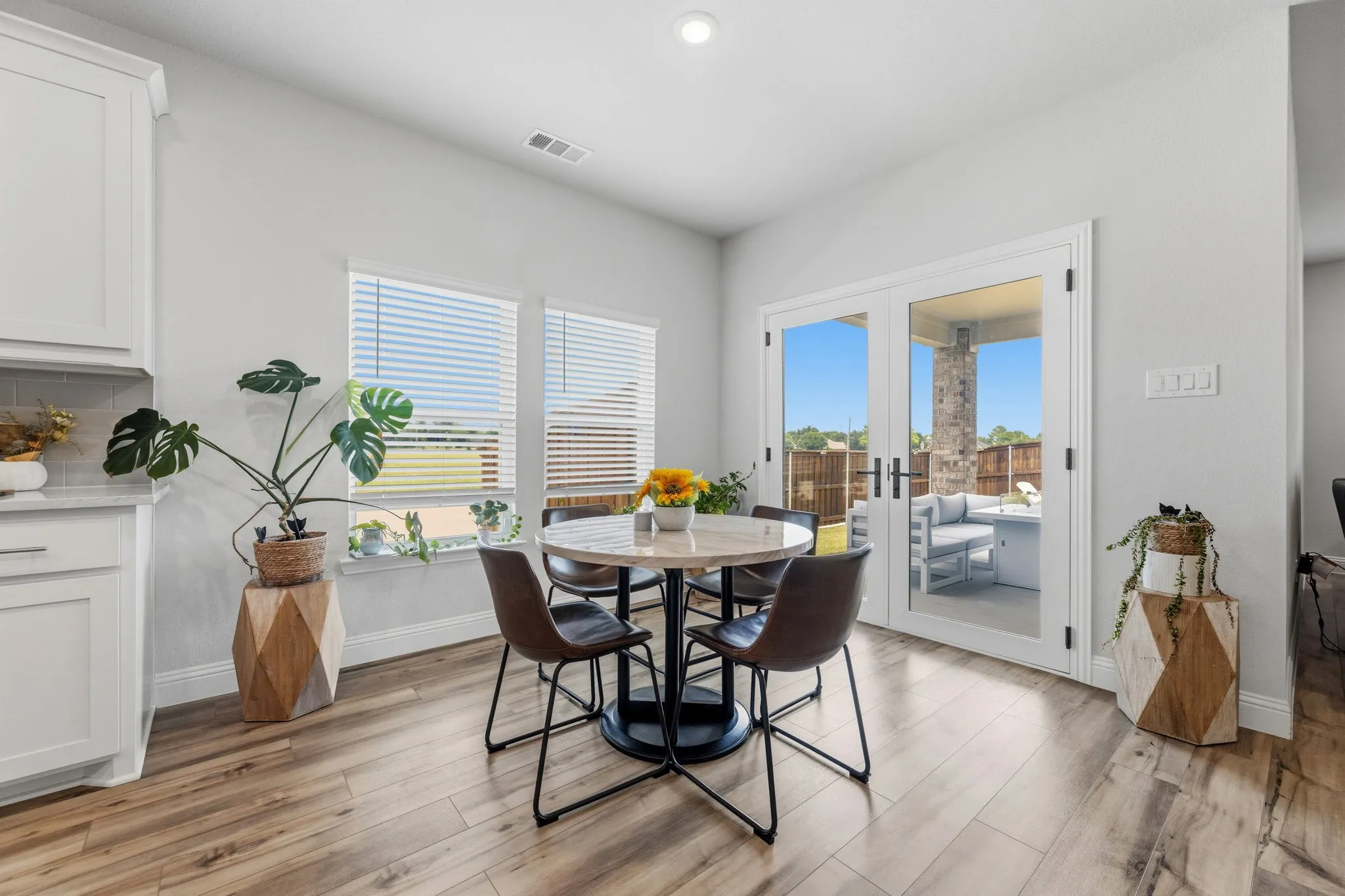 Casual dining area featuring wood-finish flooring, white cabinetry, and a light-toned countertop