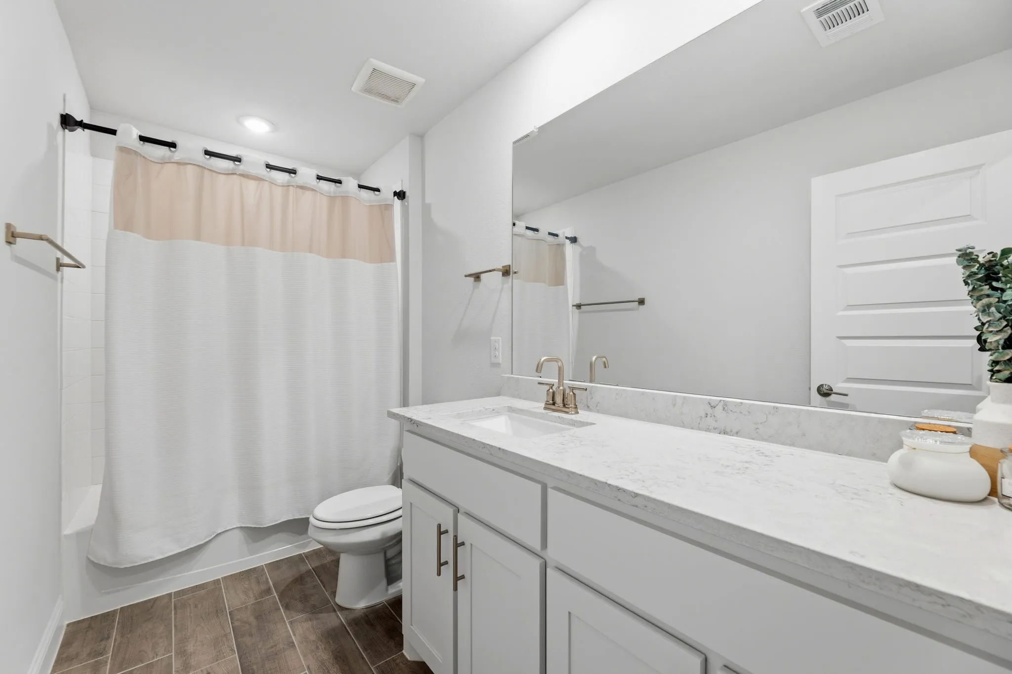 Bathroom featuring a single vanity with an undermount sink, a wide mirror, and a shower-tub combination