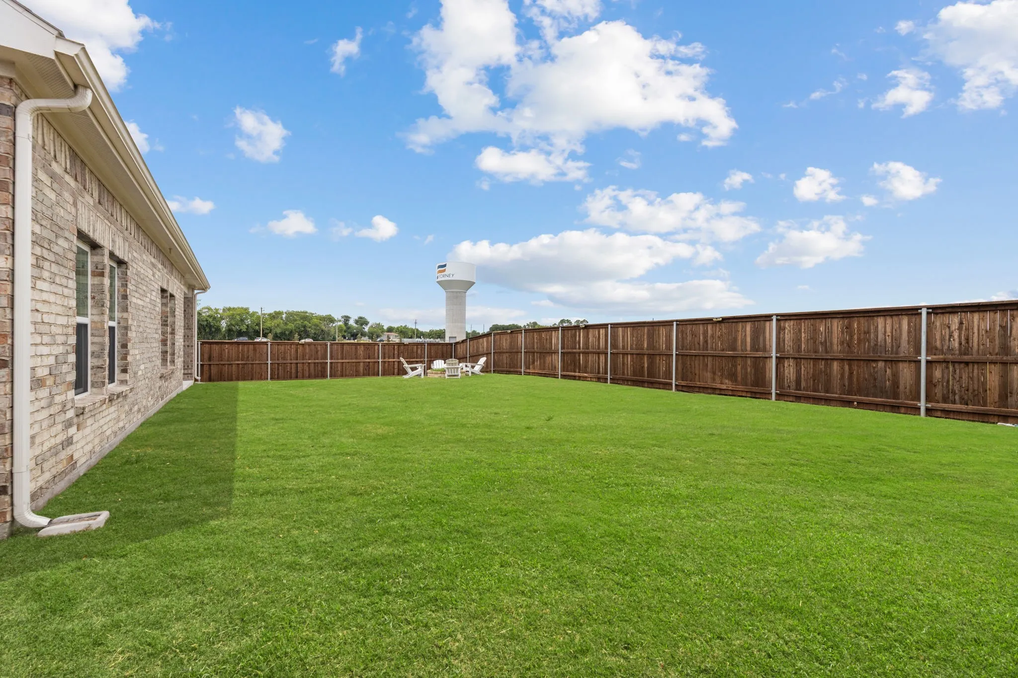 Expansive green lawn with a full privacy fence