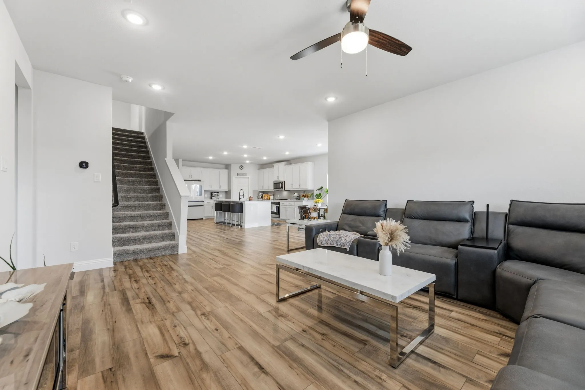 Open-concept living space featuring wood-finish flooring, recessed lighting, and a ceiling fan