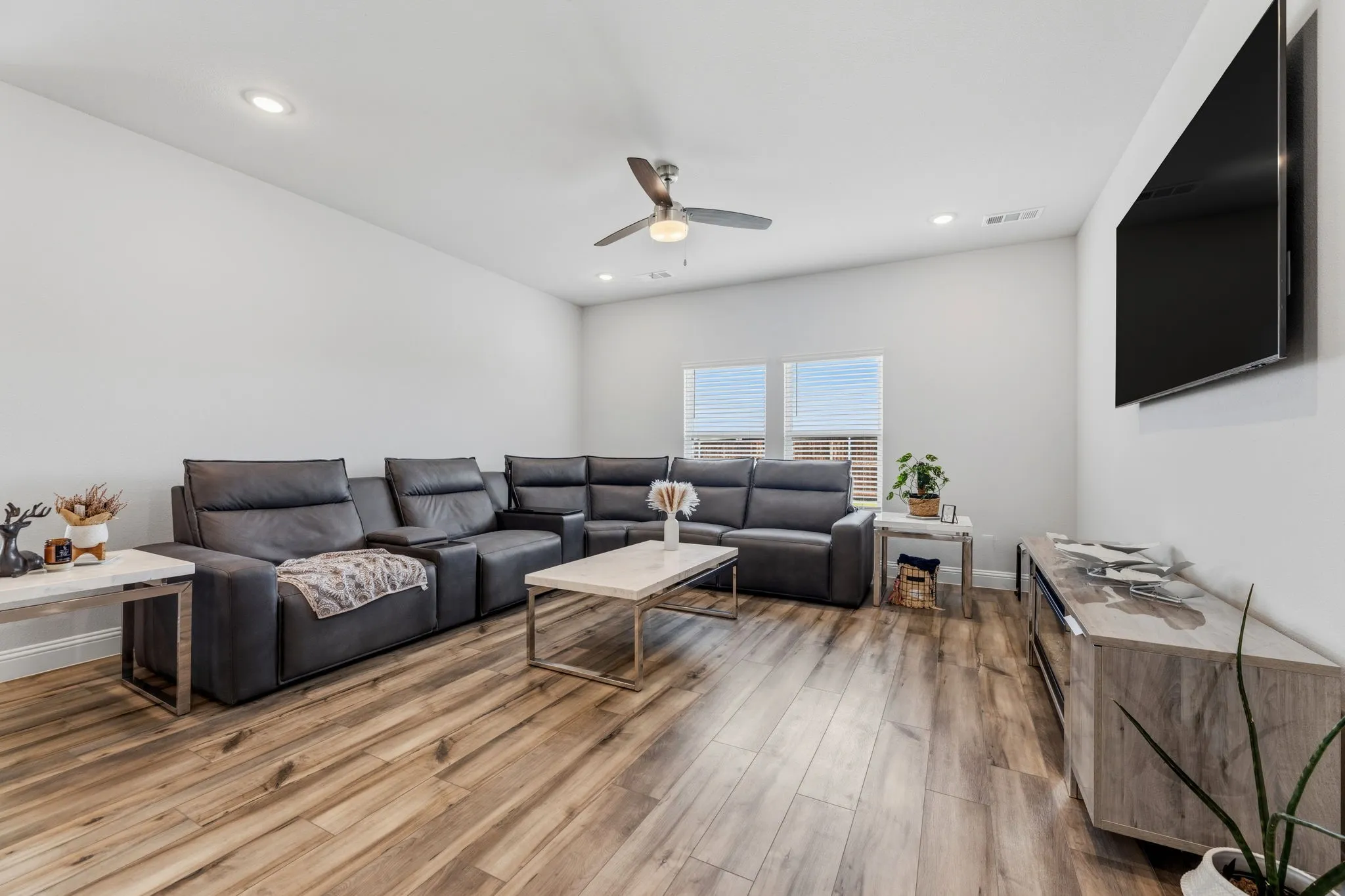 Spacious living area featuring wood-finish flooring, recessed lighting, and a ceiling fan