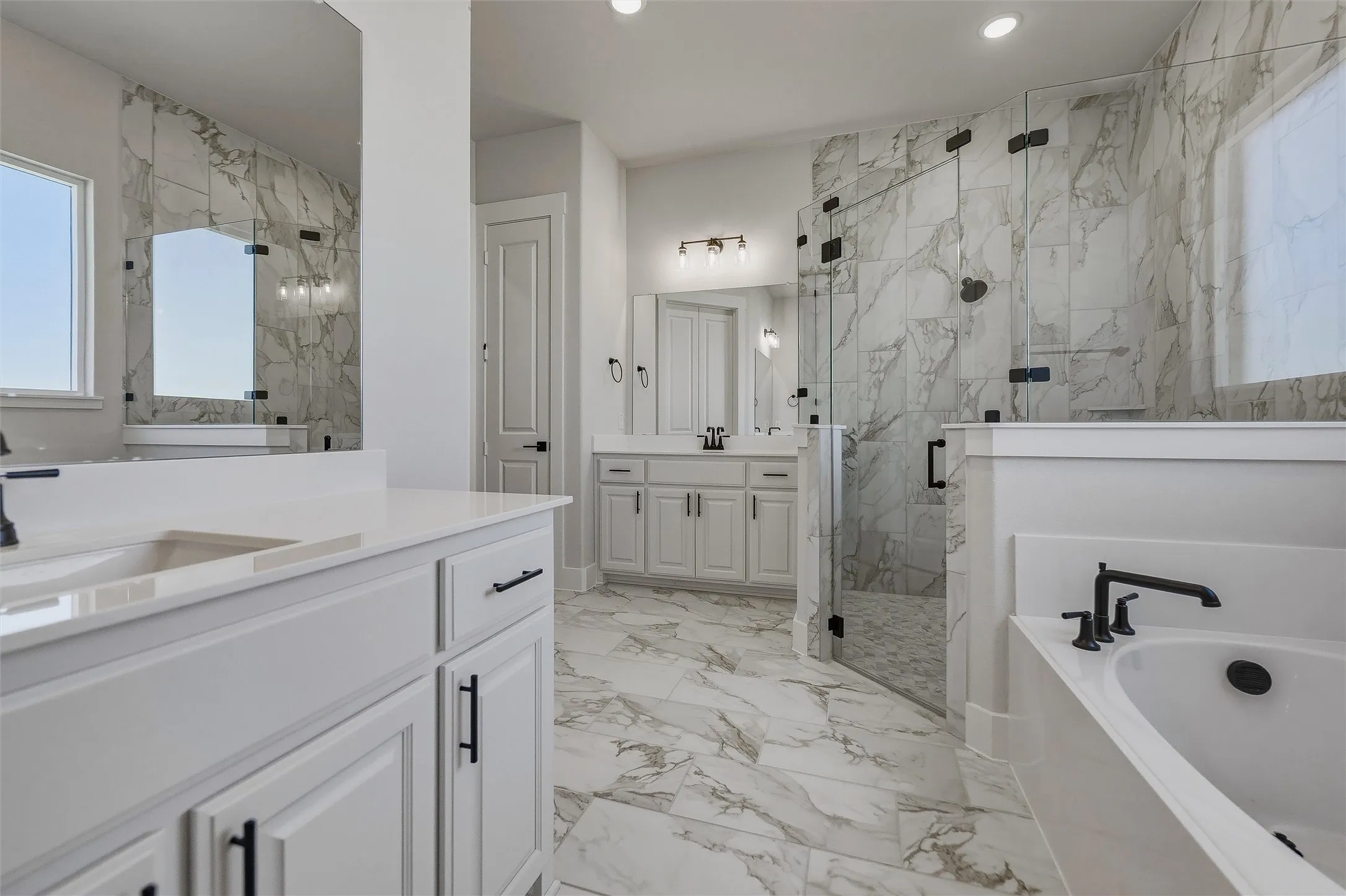 Dual vanities with white cabinetry and dark hardware