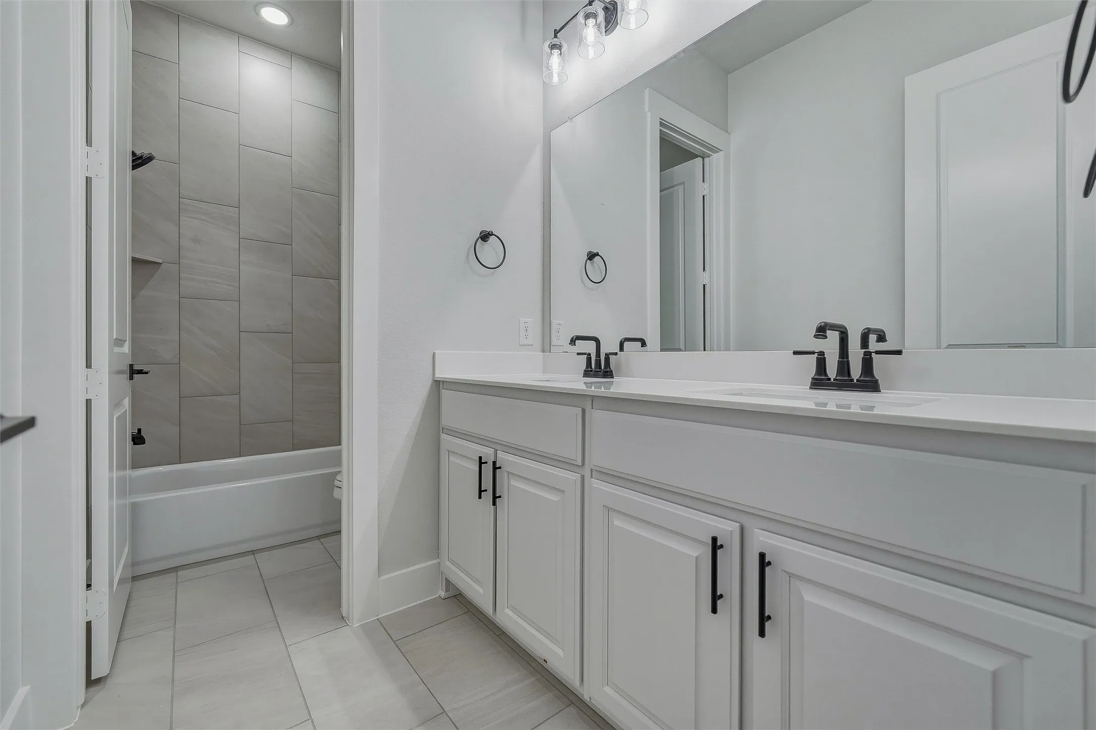 Double vanity with matte black fixtures and white countertops