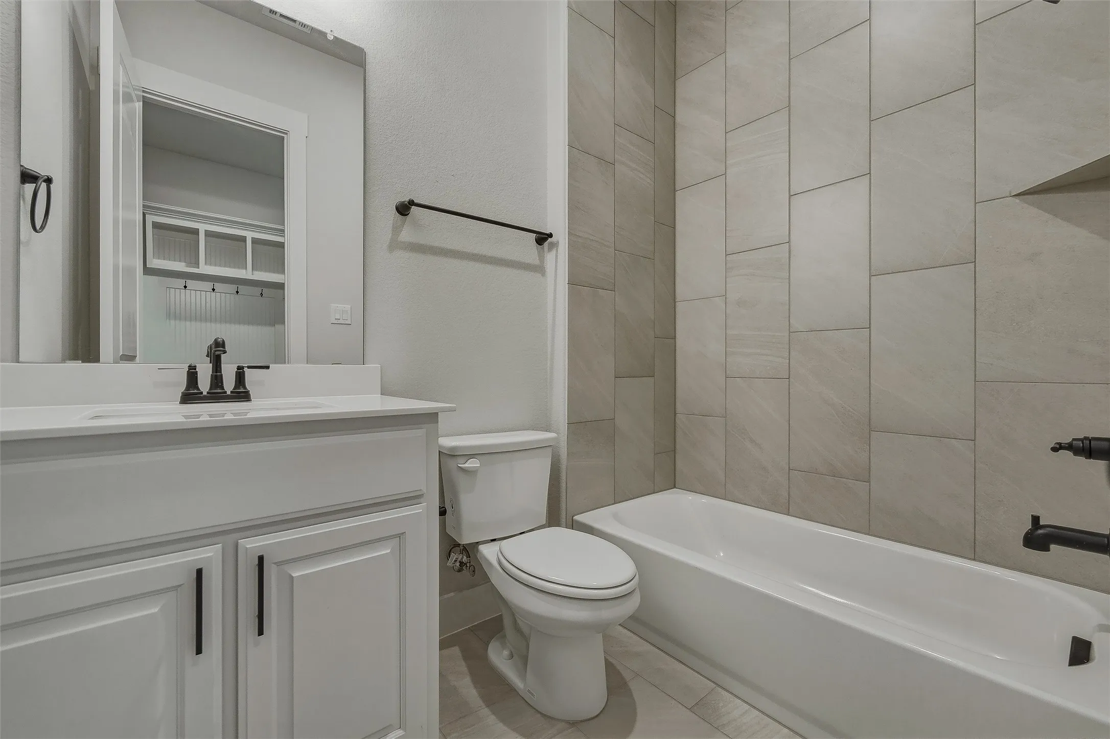 White vanity with a single basin, matte black faucet, and white countertop
