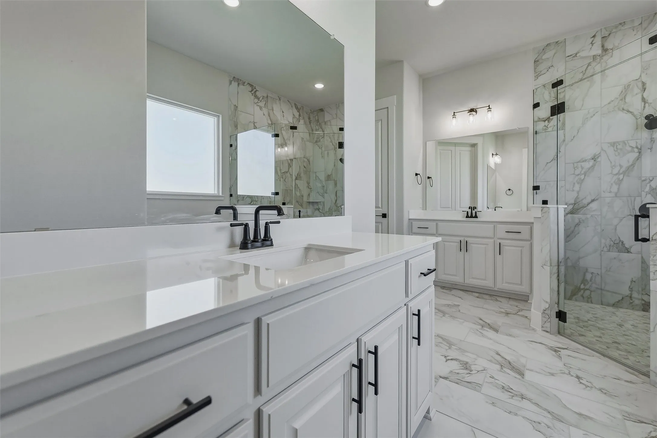 Dual vanity with white cabinetry, matte black hardware, and integrated sinks