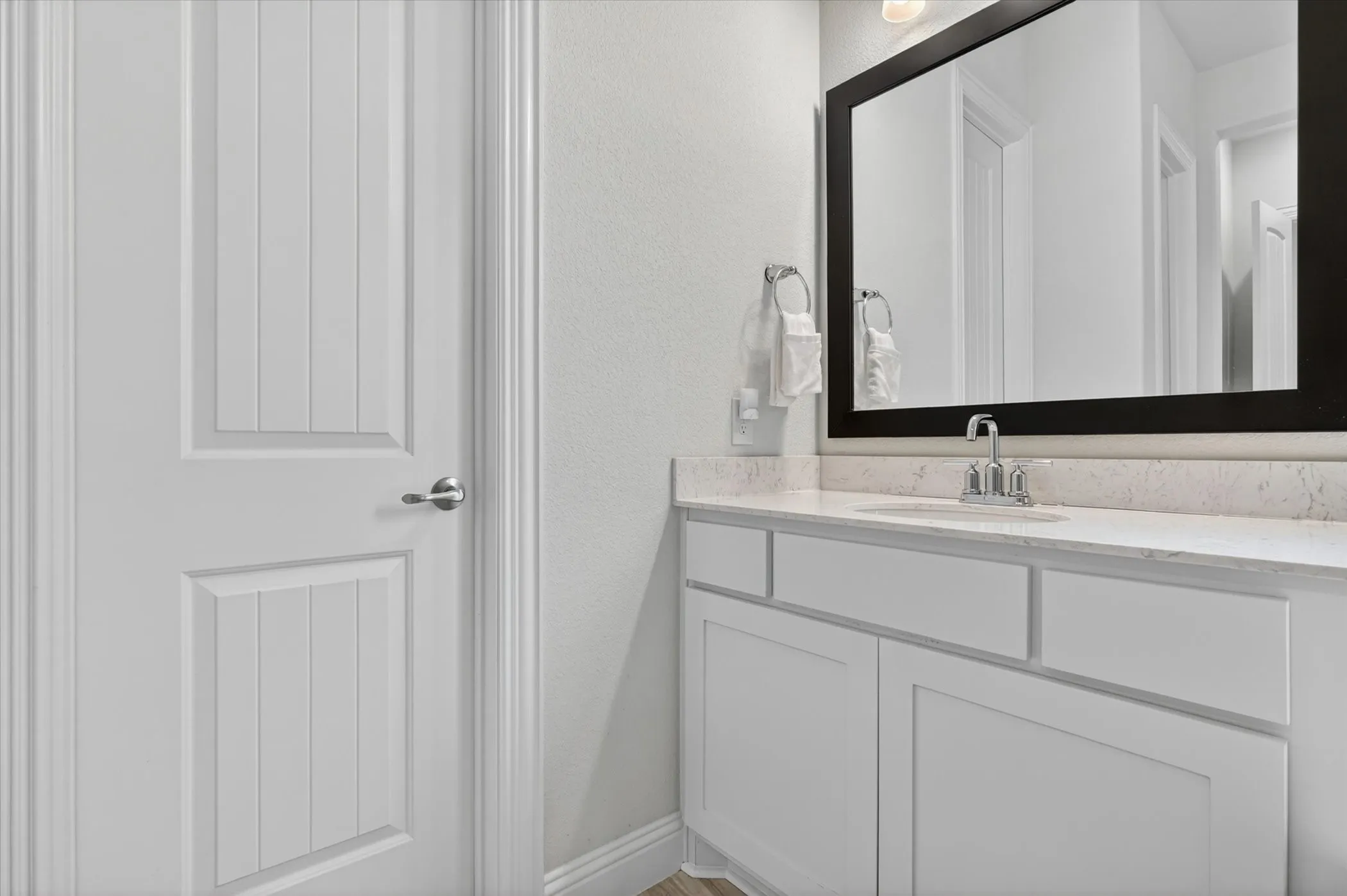 Vanity featuring a light-colored countertop, undermount sink, and chrome faucet
