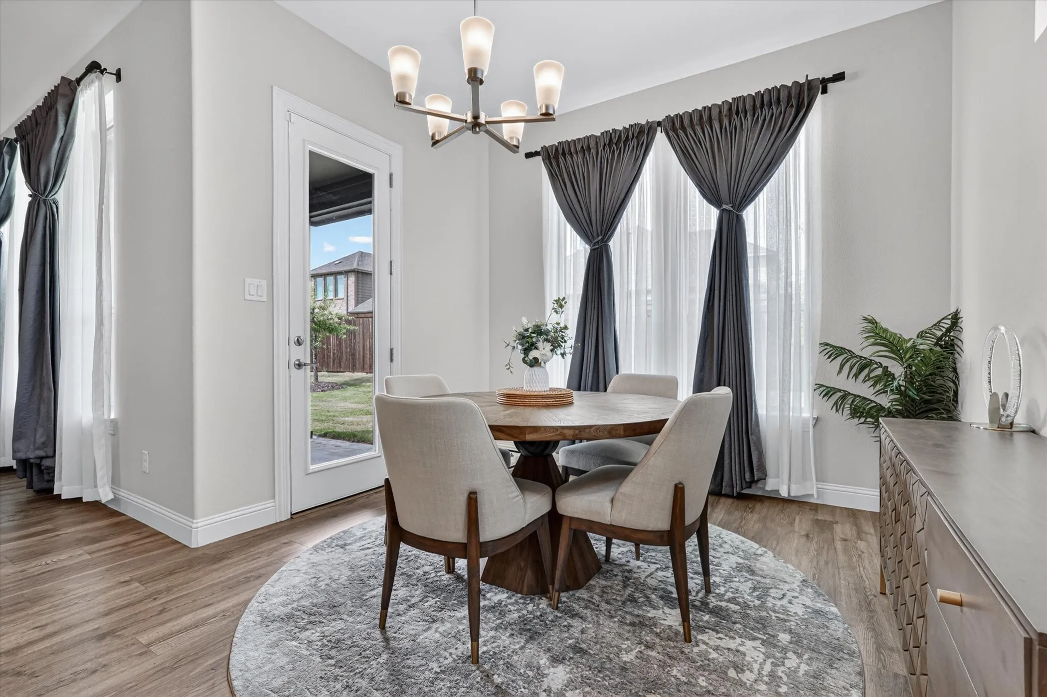 Dining area featuring wood-finish flooring, a full-lite glass door, and a multi-light chandelier
