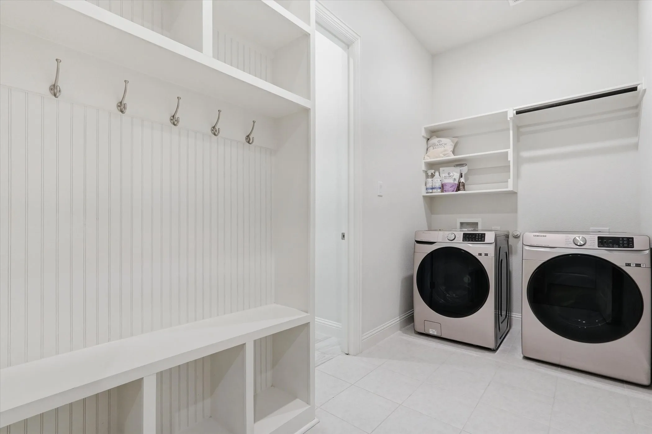 Mudroom and utility area featuring a built-in bench with cubbies, beadboard paneling, and wall-mounted coat hooks