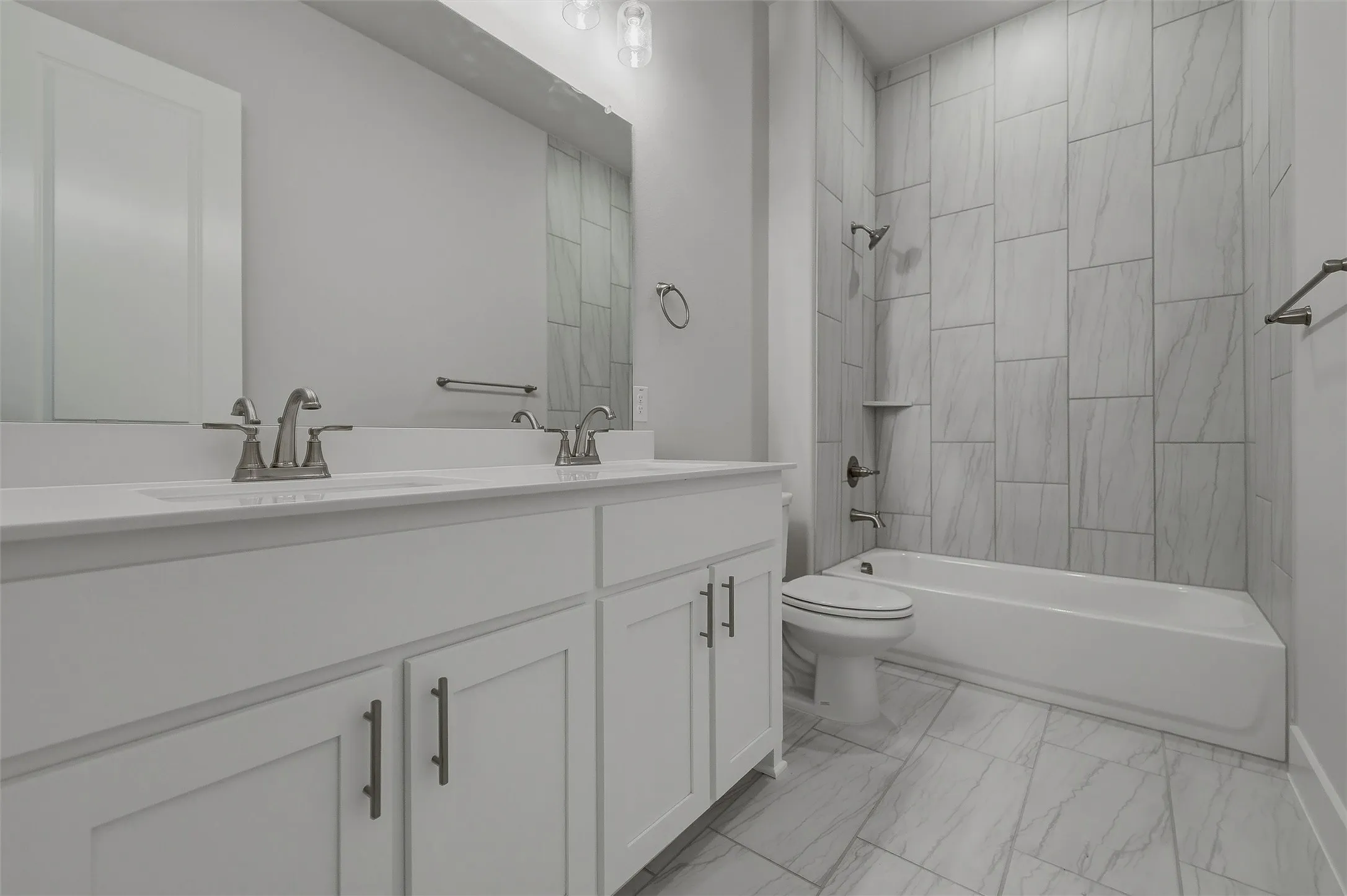 Dual vanity with white cabinetry and brushed nickel hardware, white countertop, and tile flooring