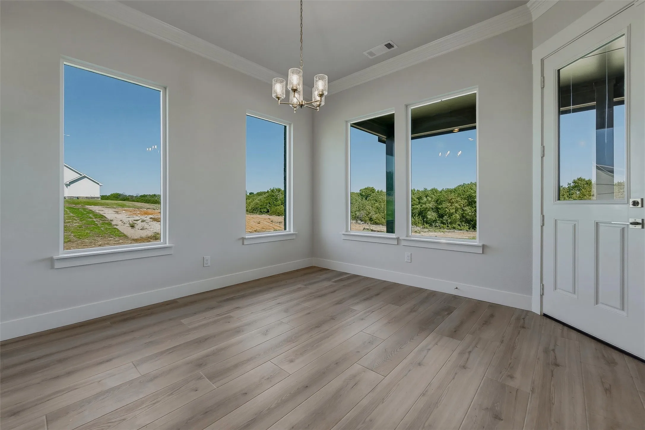 Light wood-finish flooring with white trim