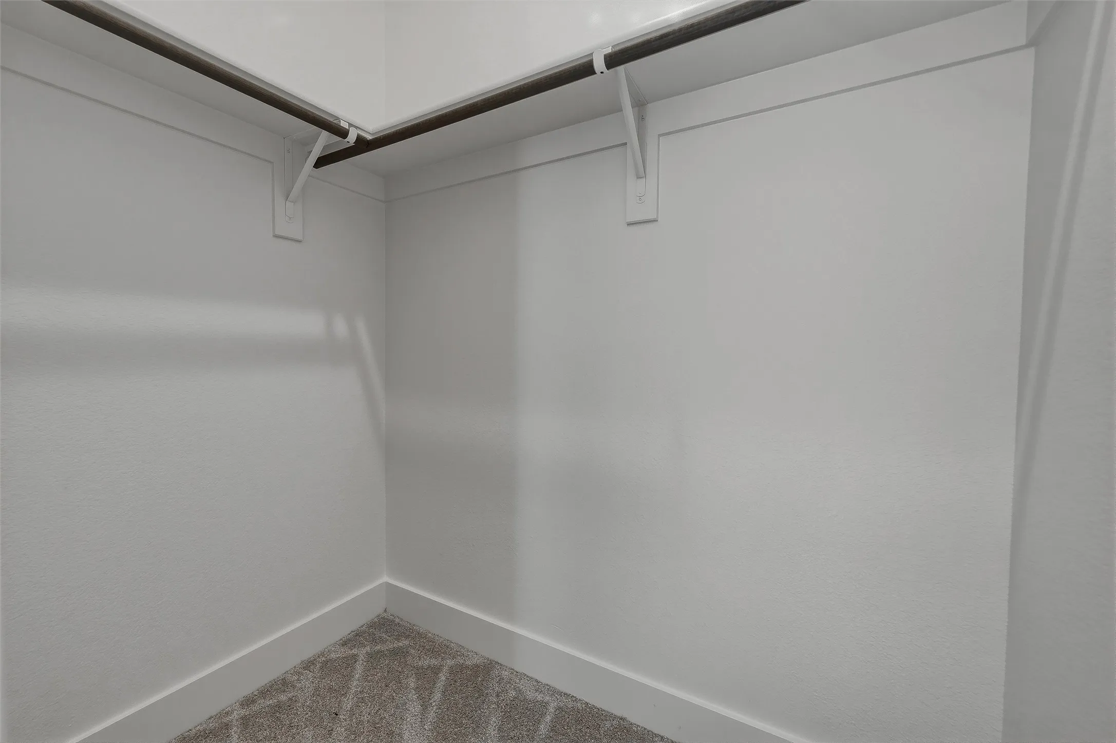 Walk-in closet with wall-mounted shelving and hanging rods