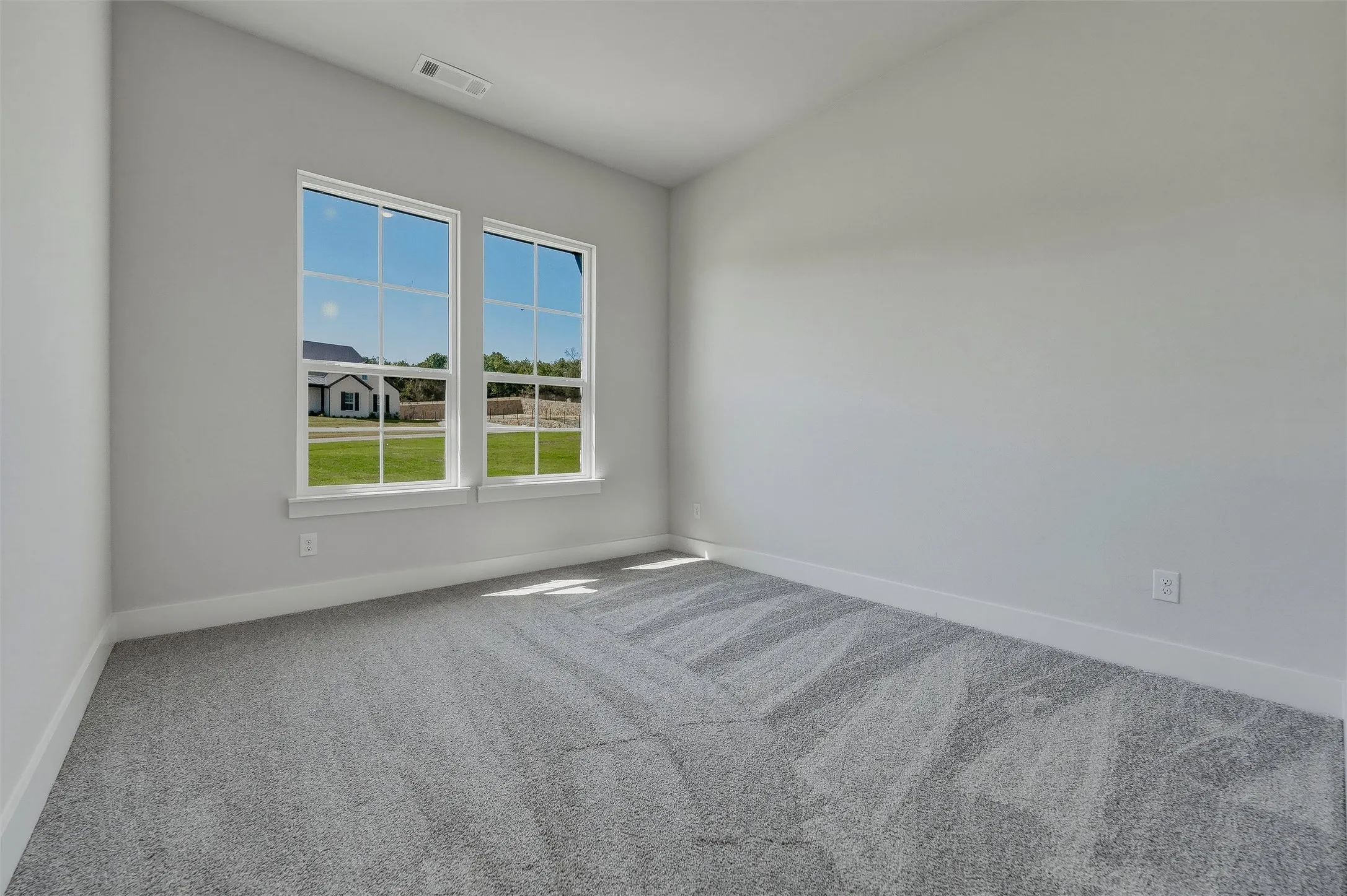 Neutral wall color, patterned carpeting, and white trim