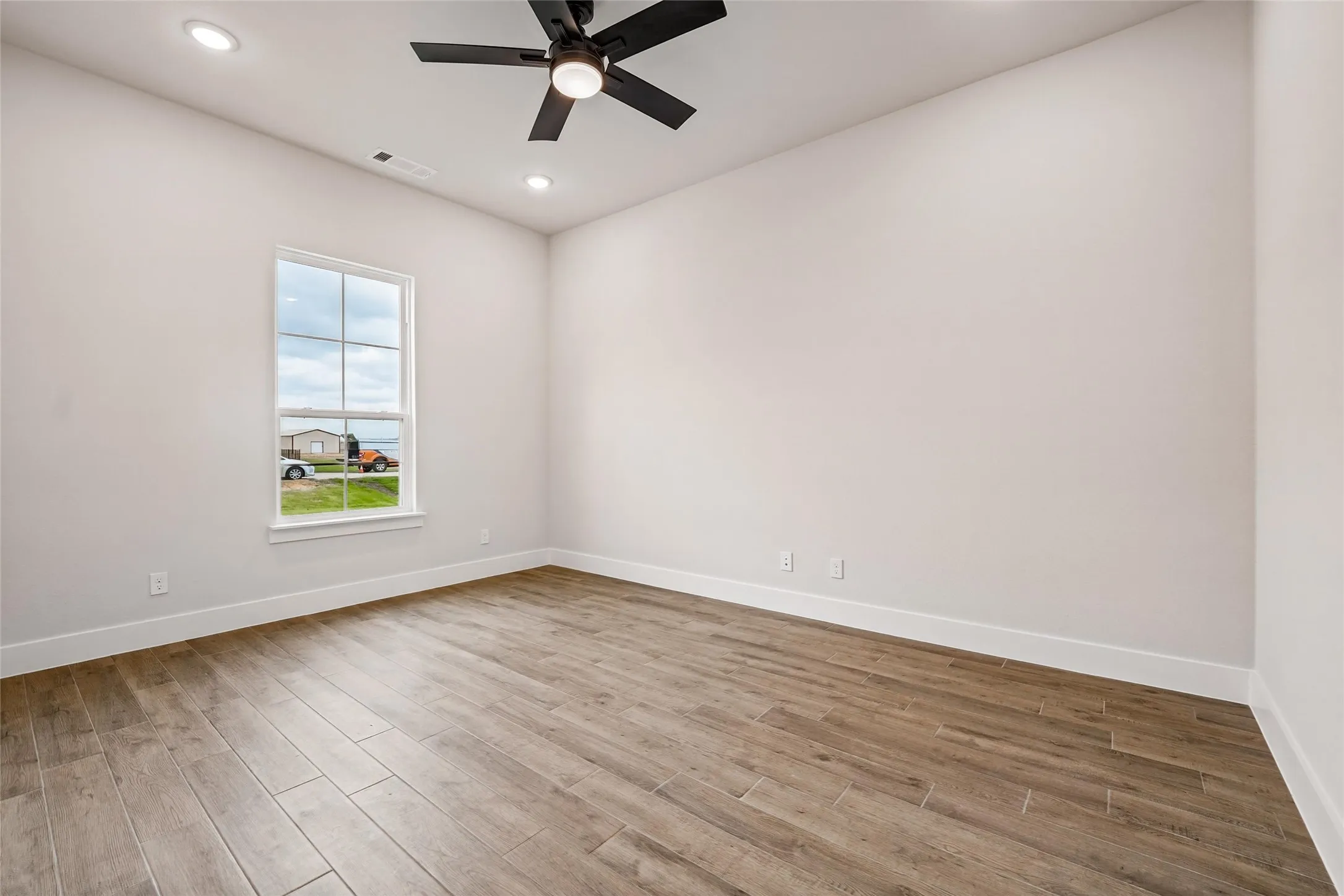 Wood-finish plank flooring, recessed lighting, and a ceiling fan with integrated lighting