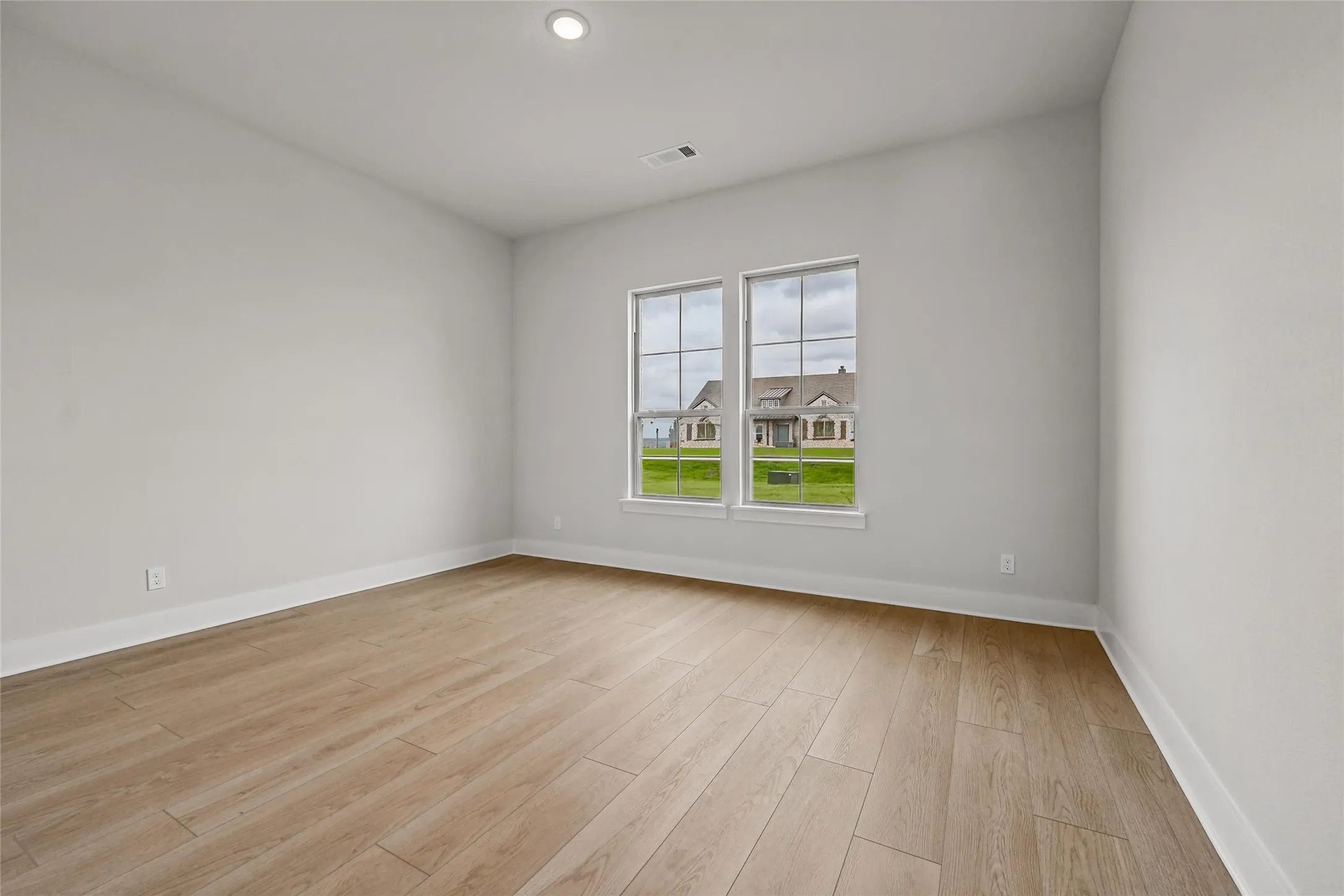 Recessed lighting, wood-finish flooring, and white trim