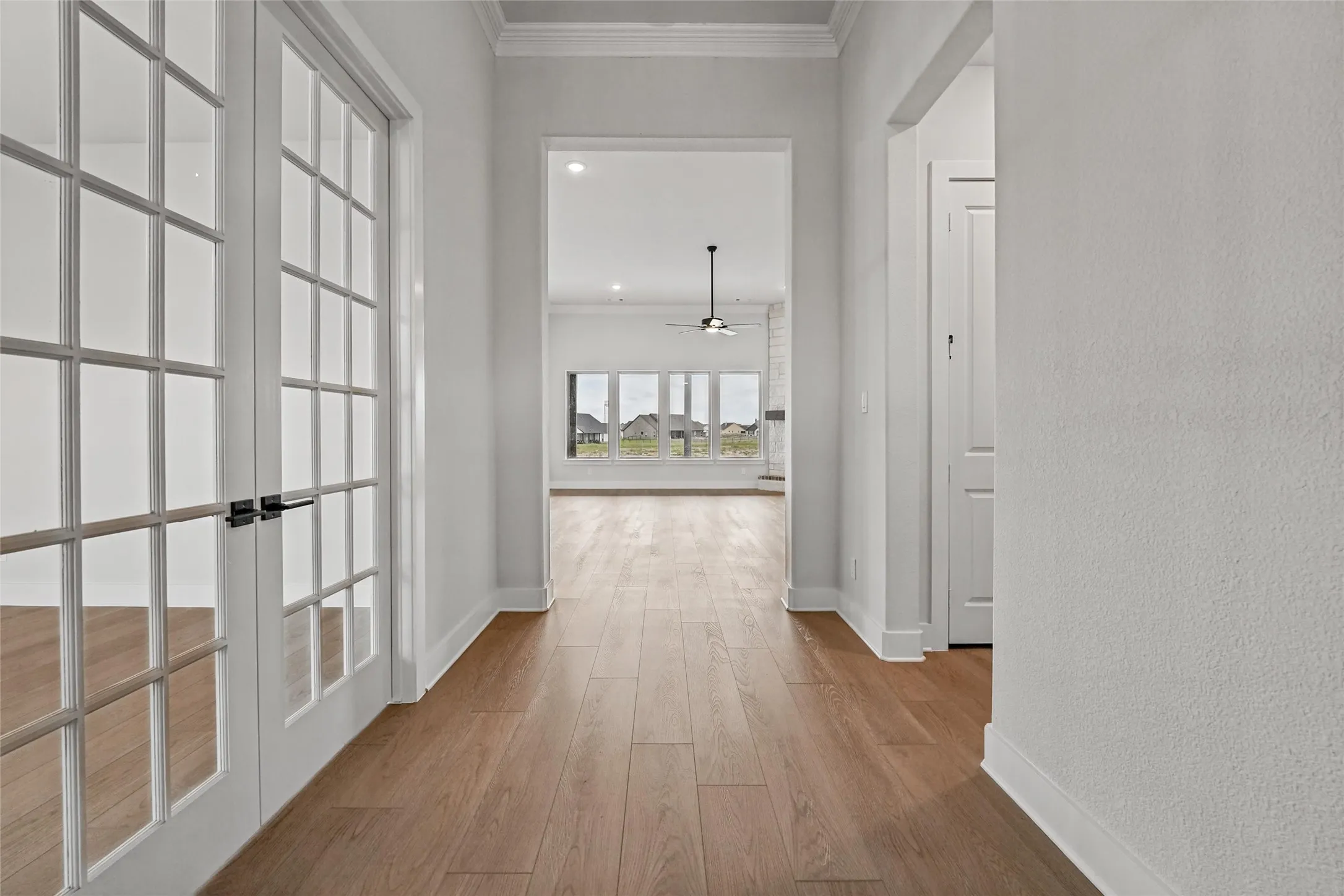 French doors with matte black hardware, wood-finish flooring, recessed lighting, and crown molding
