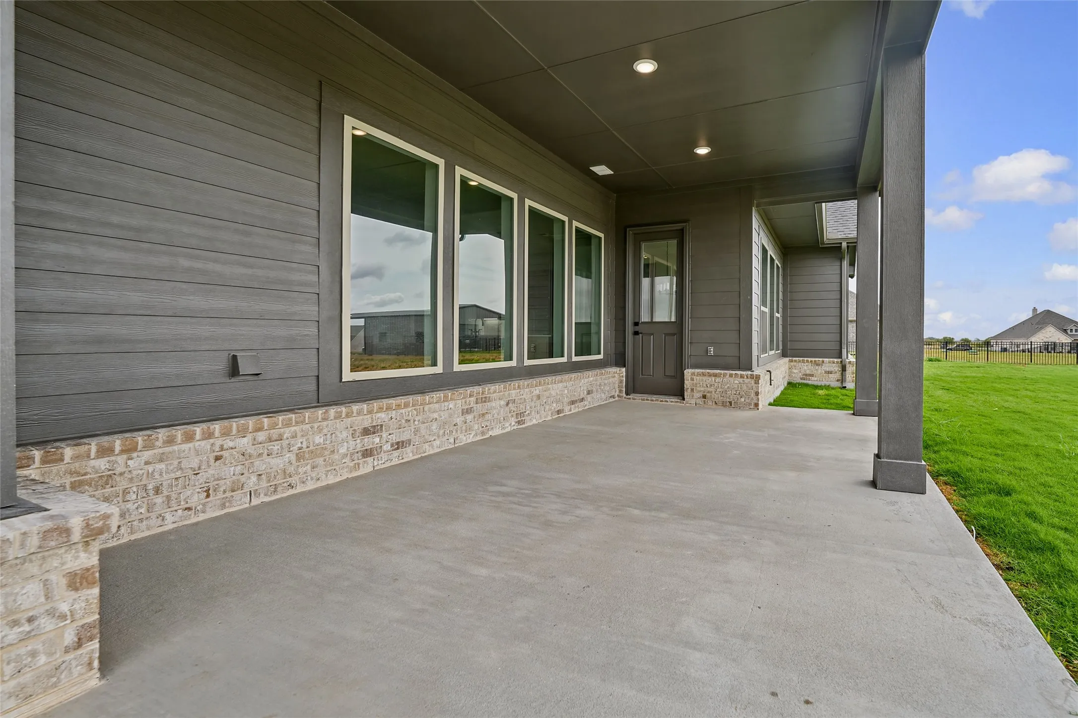 Covered patio with a concrete surface, supported by architectural columns