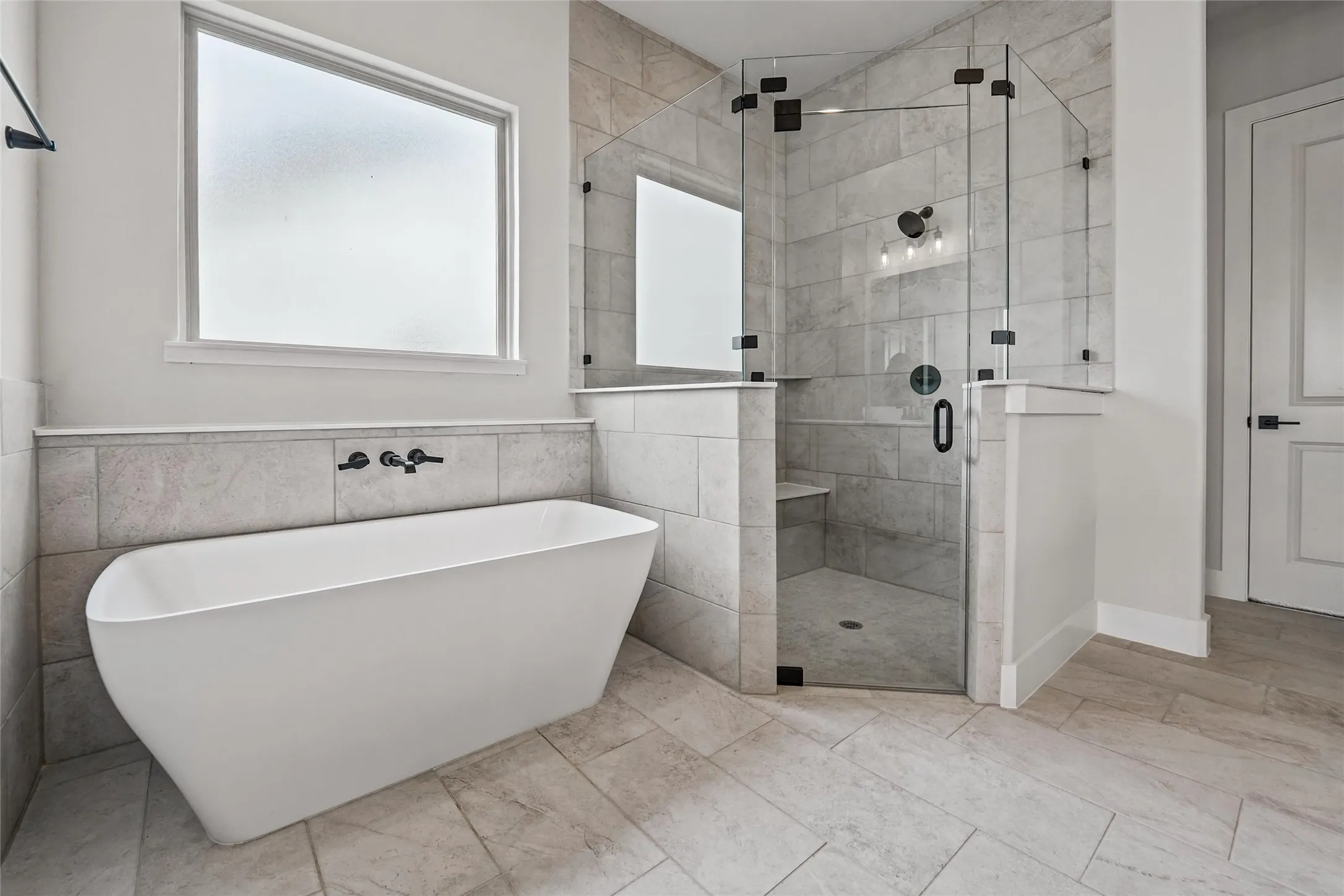 Freestanding soaking tub with wall-mounted fixtures