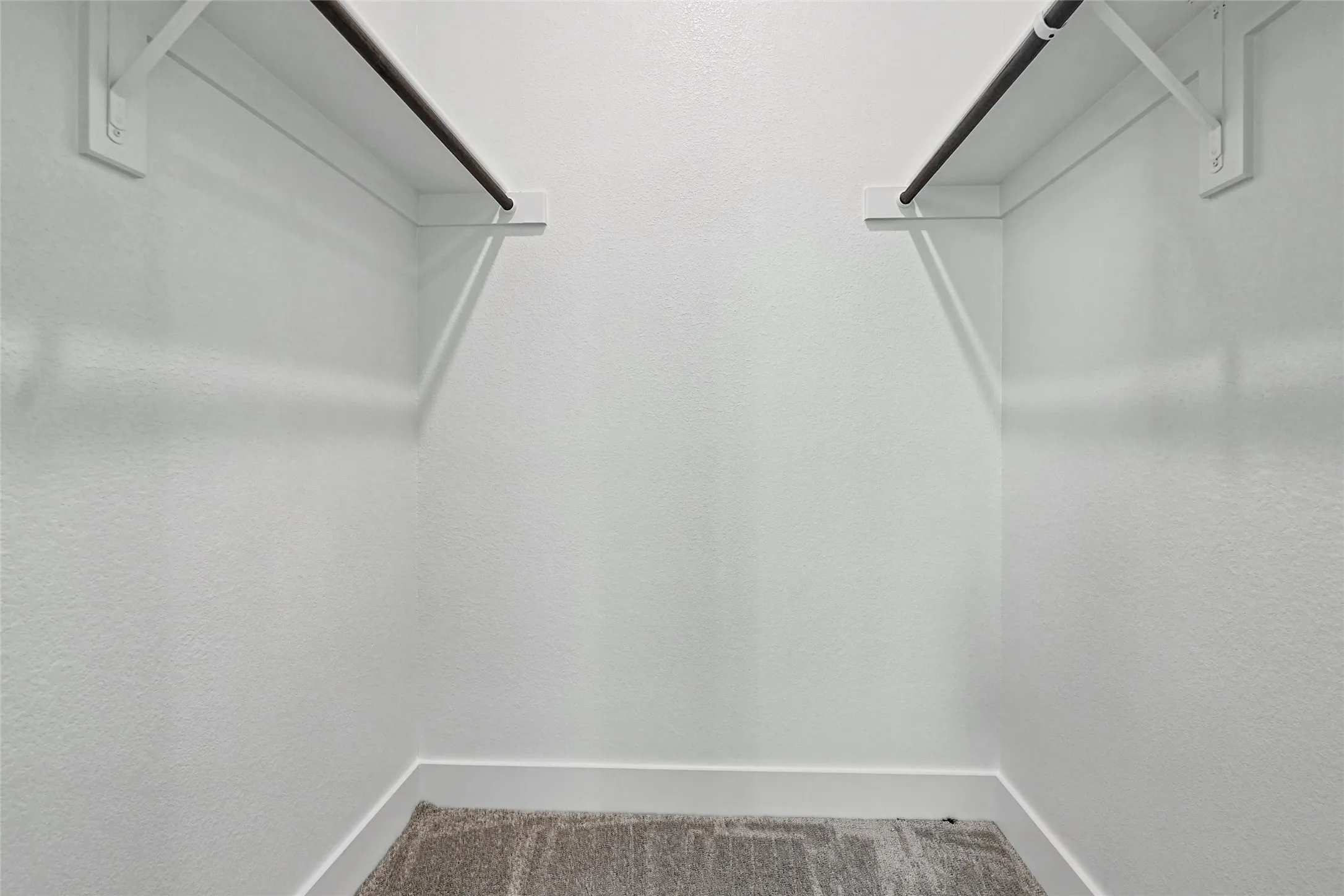 Built-in shelving with hanging rods and neutral wall finish