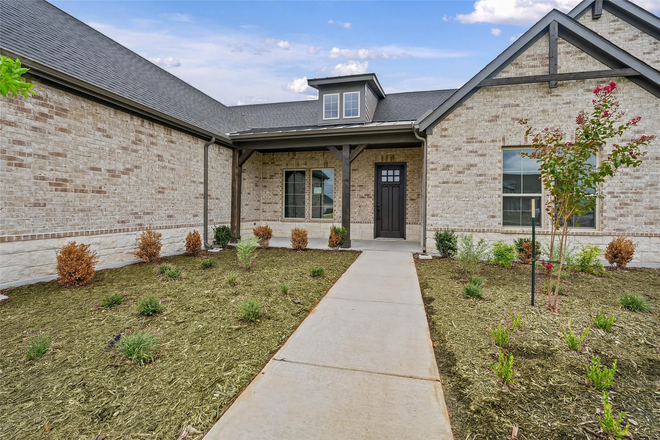 Brick and stone veneer exterior with dark trim accents