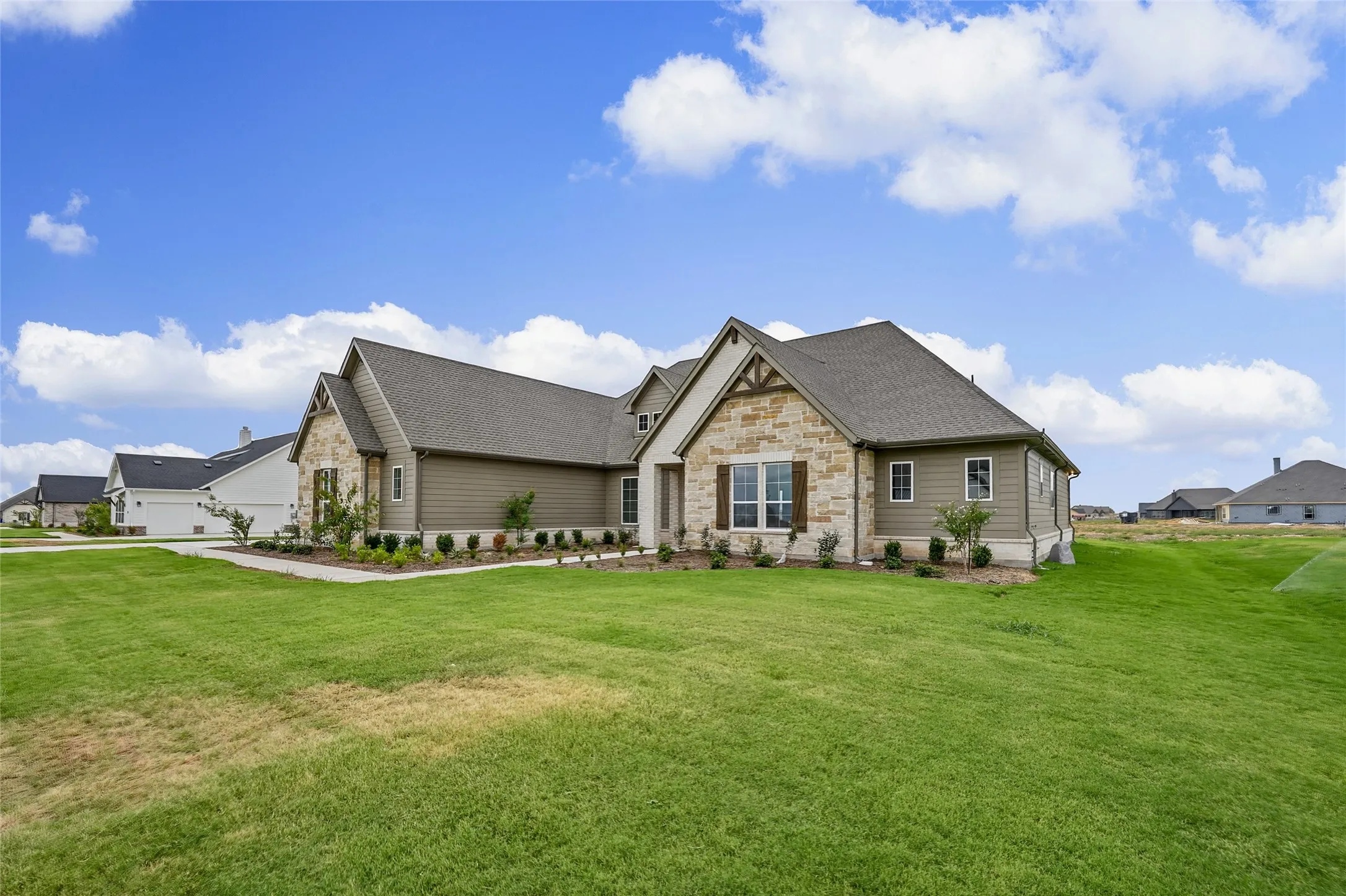 Stone and siding exterior with dark shingle roofing
