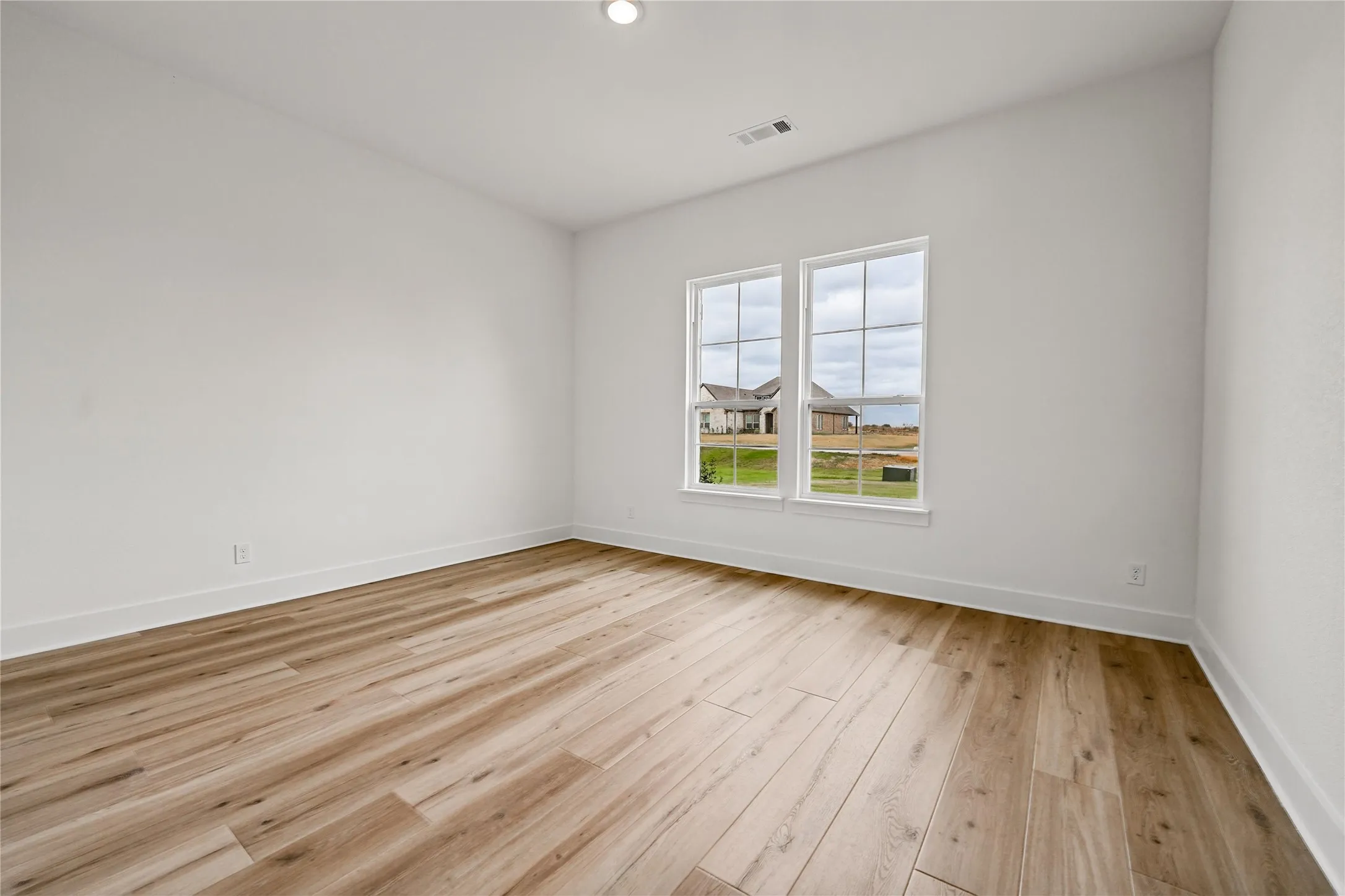 Wood-finish flooring with crisp white walls and dual pane windows