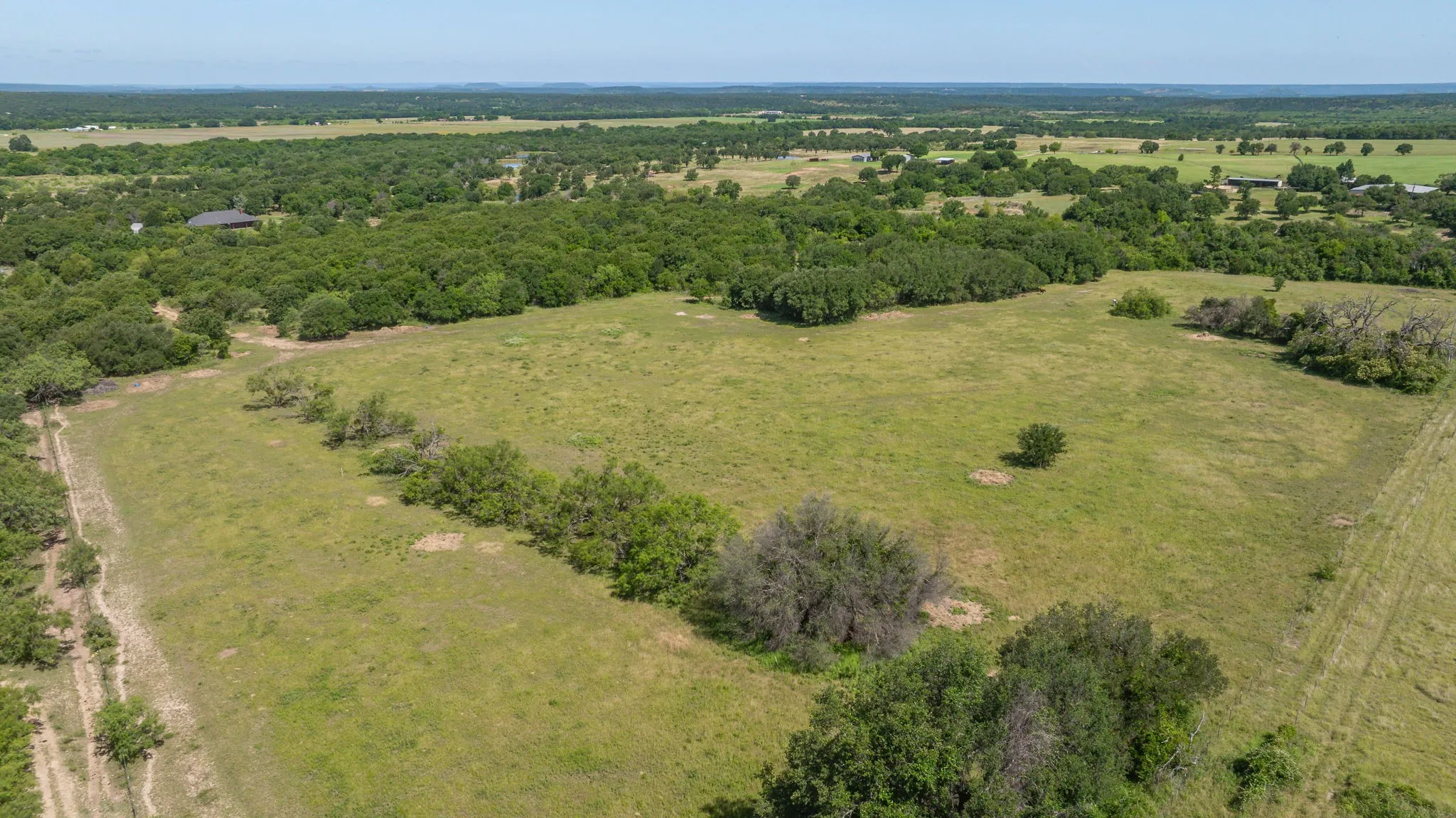 Expansive cleared land featuring scattered trees and a natural landscape