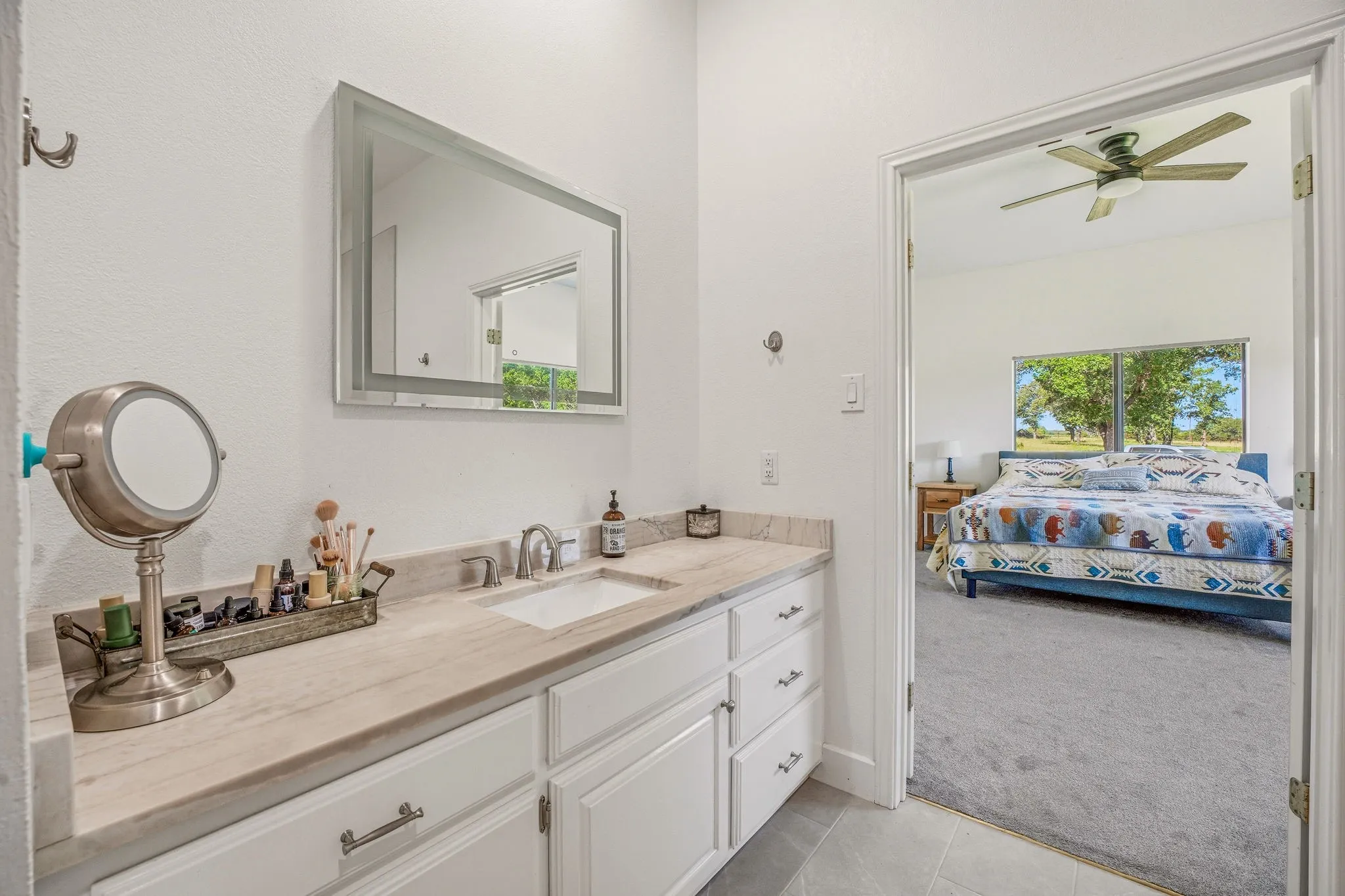 Bathroom vanity with a rectangular undermount sink, dual handle faucet, and stone countertop