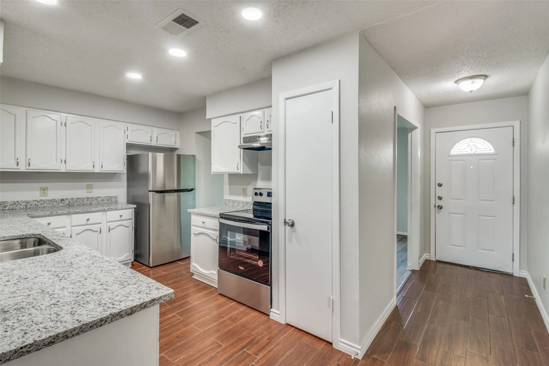 Kitchen featuring white cabinetry and light-toned countertops