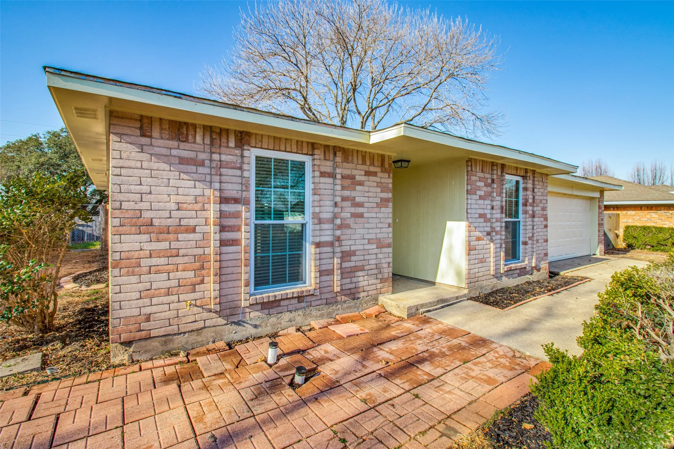 Brick exterior featuring an integrated garage